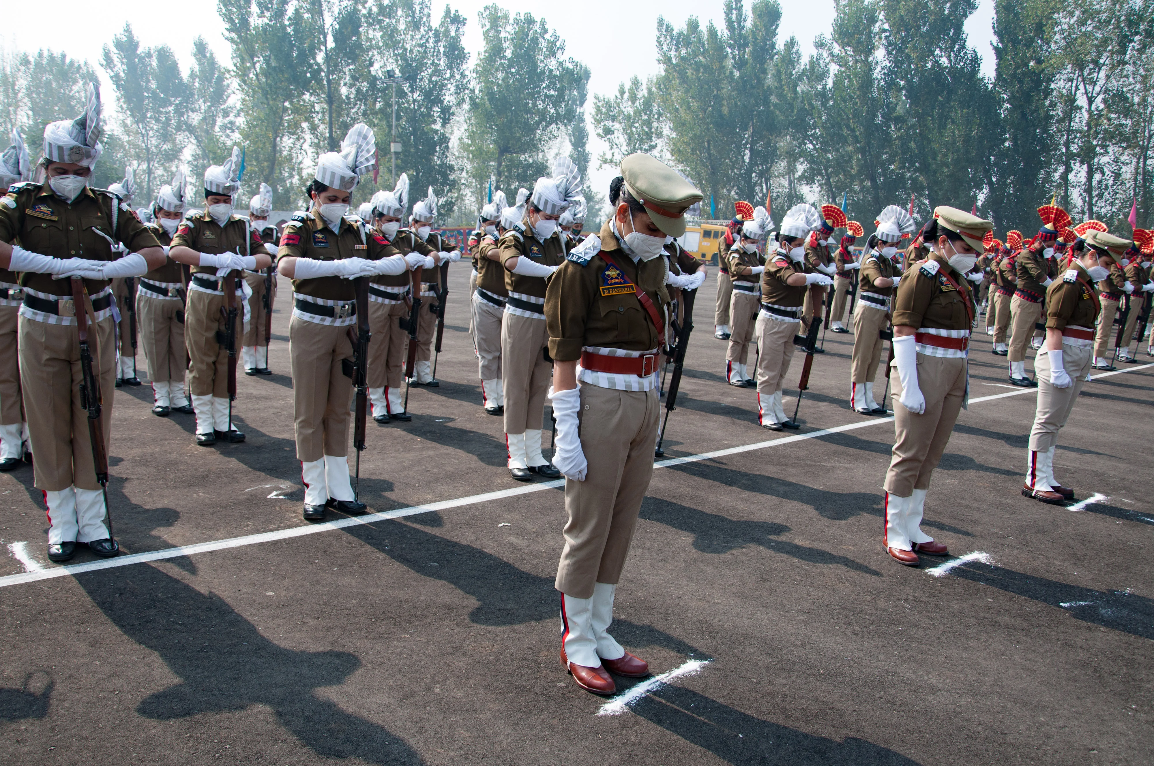 Policewomen bow their head in honor of the slain colleagues during a ceremony to mark the National Police Commemoration Day at the Police Training Centre in Zewan on the outskirts of Srinagar, on Thursday 21 October 2021.
