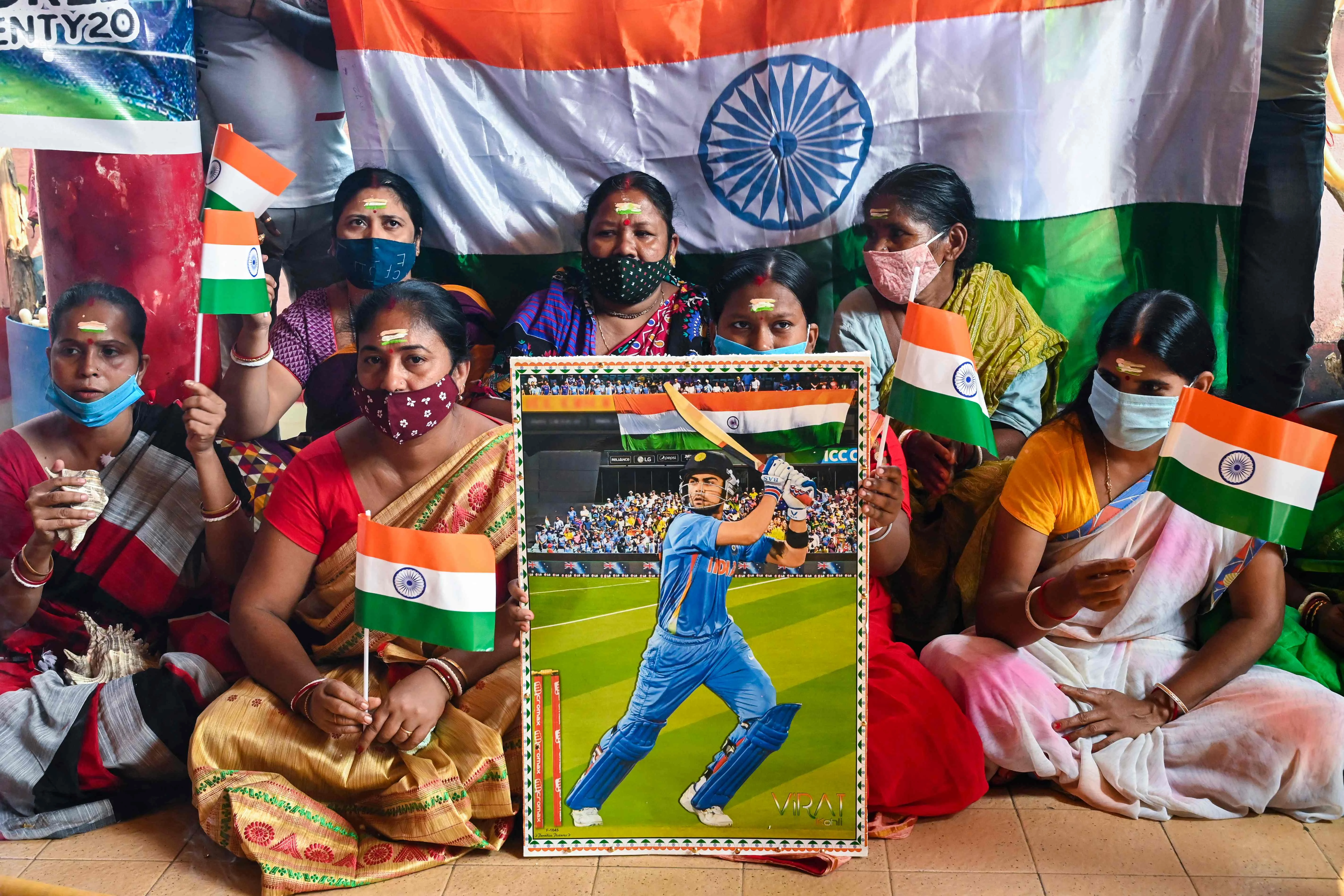 Cricket fans hold a placard with the picture of Indias captain Virat Kohli (C) as they perform rituals wishing the victory of the Indian cricket team ahead of their ICC T20 World Cup 2021 cricket match against Pakistan played in Dubai, in Kolkata on October 24, 2021.