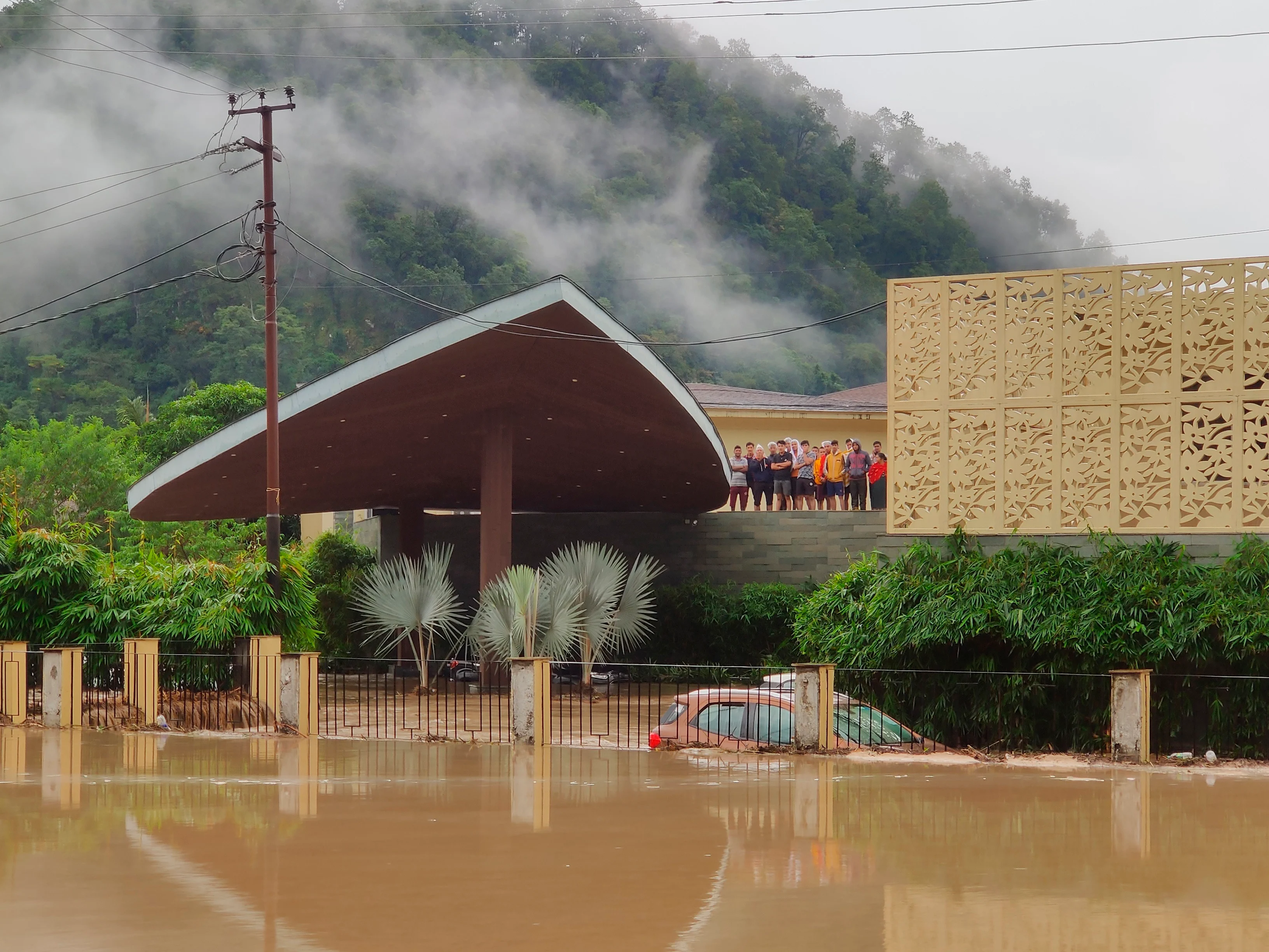 Jim Corbett National Park: Hotel guests stand on the roof of Lemon Tree hotel, as the hotel gets flooded with the waters from an overflowing Kosi River in Jim Corbett National Park, Uttarakhand state, Tuesday, Oct. 19, 2021. More than 20 people have died and many are missing in floods triggered by heavy rains in the northern Indian state of Uttarakhand, officials said Tuesday.