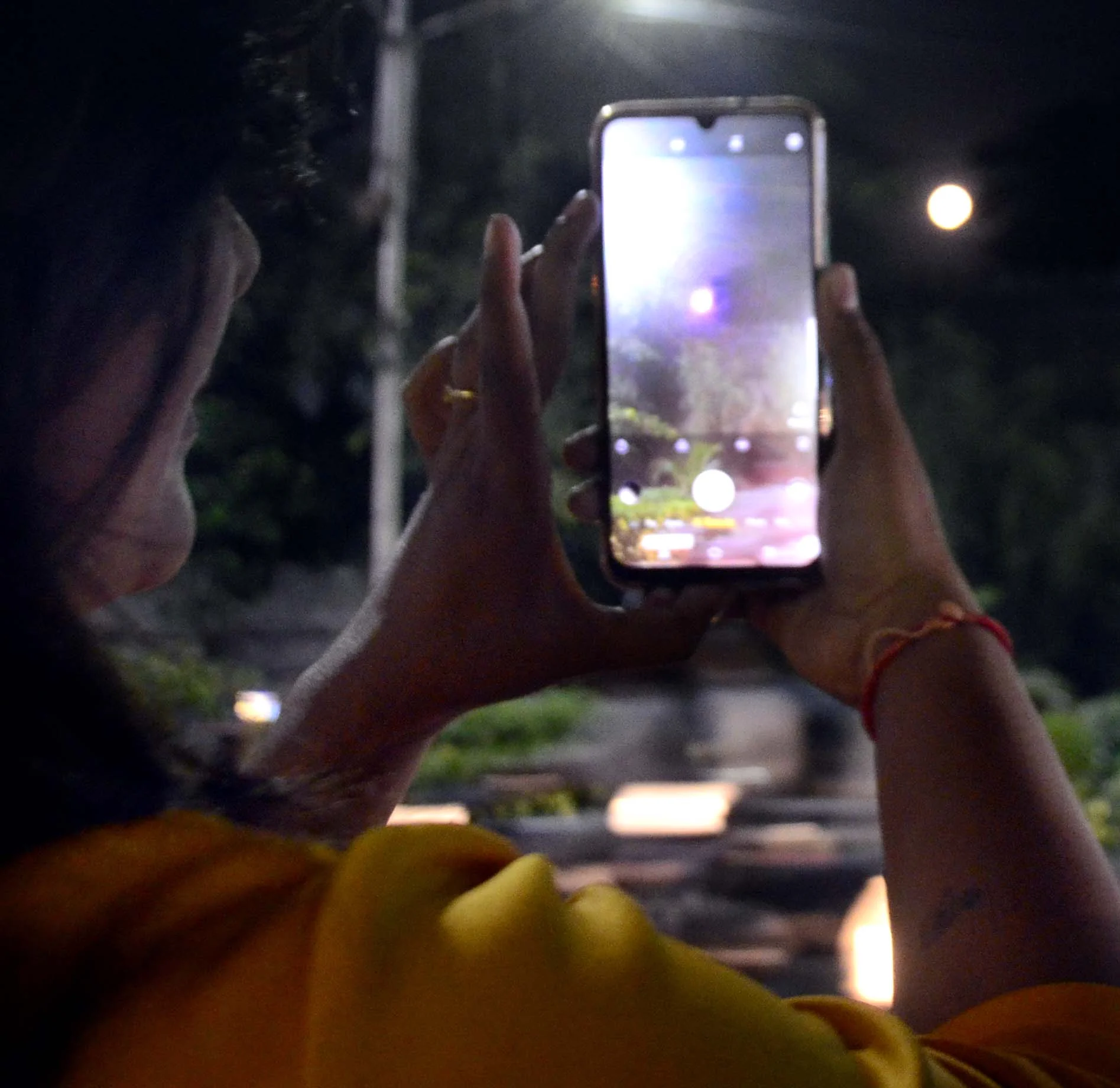 A girl clicks picture of full Moon during Sharad Purnima in Bhopal on Wednesday.