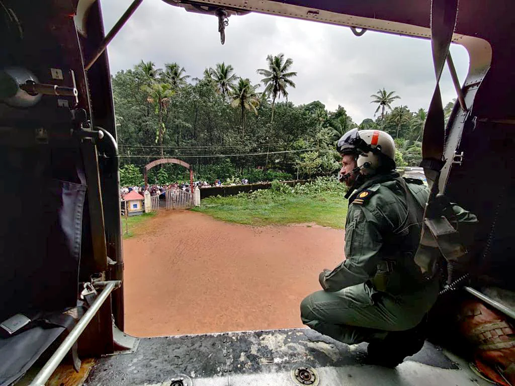 Kochi Southern Naval Command (SNC) personnel inside a chopper on the way to provide relief material to landslide affected areas, at Koottickal, in Kottayam on Sunday.