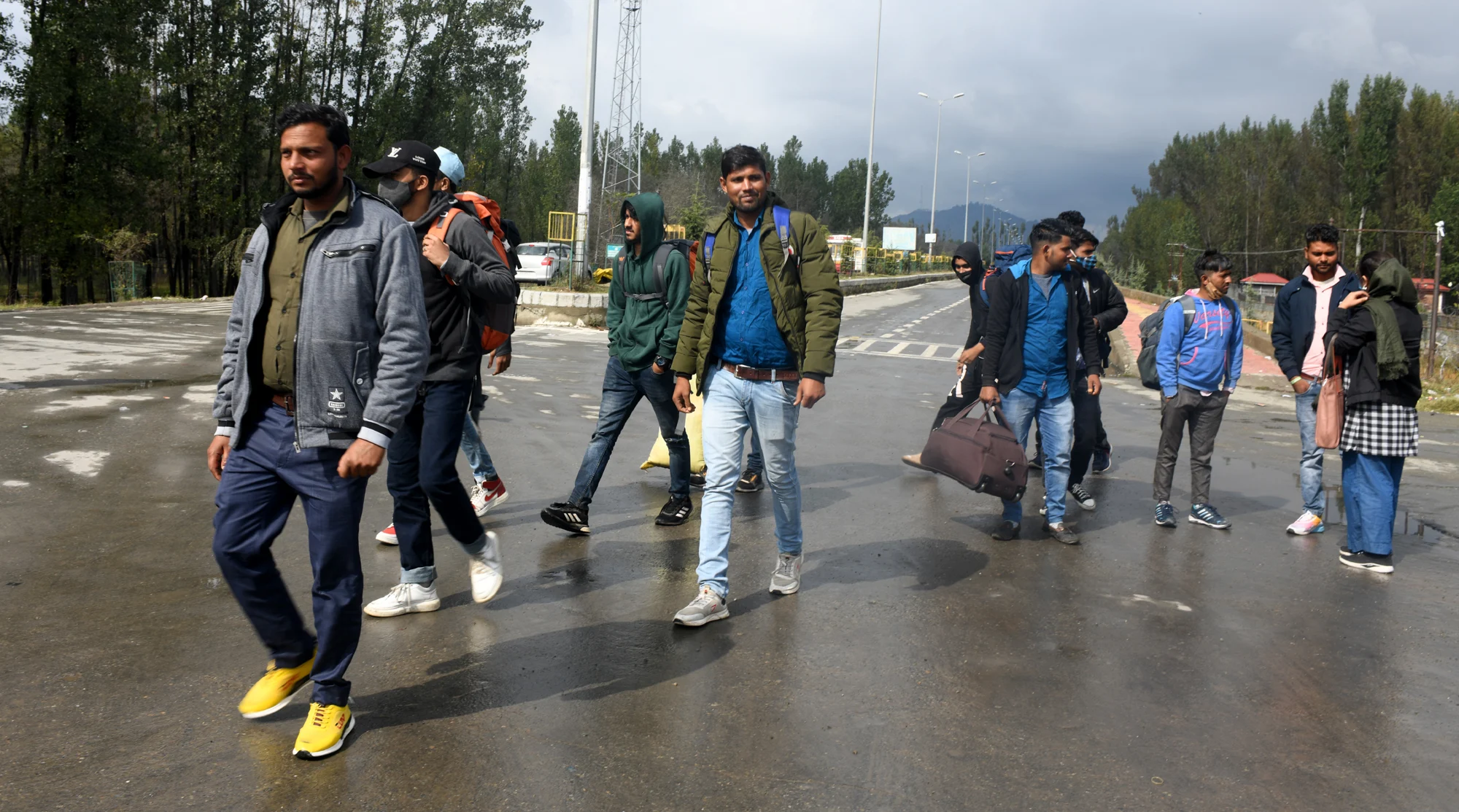 Group of Migrant workers walk towards a railway station in Srinagar to return to their home after fresh of violence against civillians including non locals in the past week across Kashmir