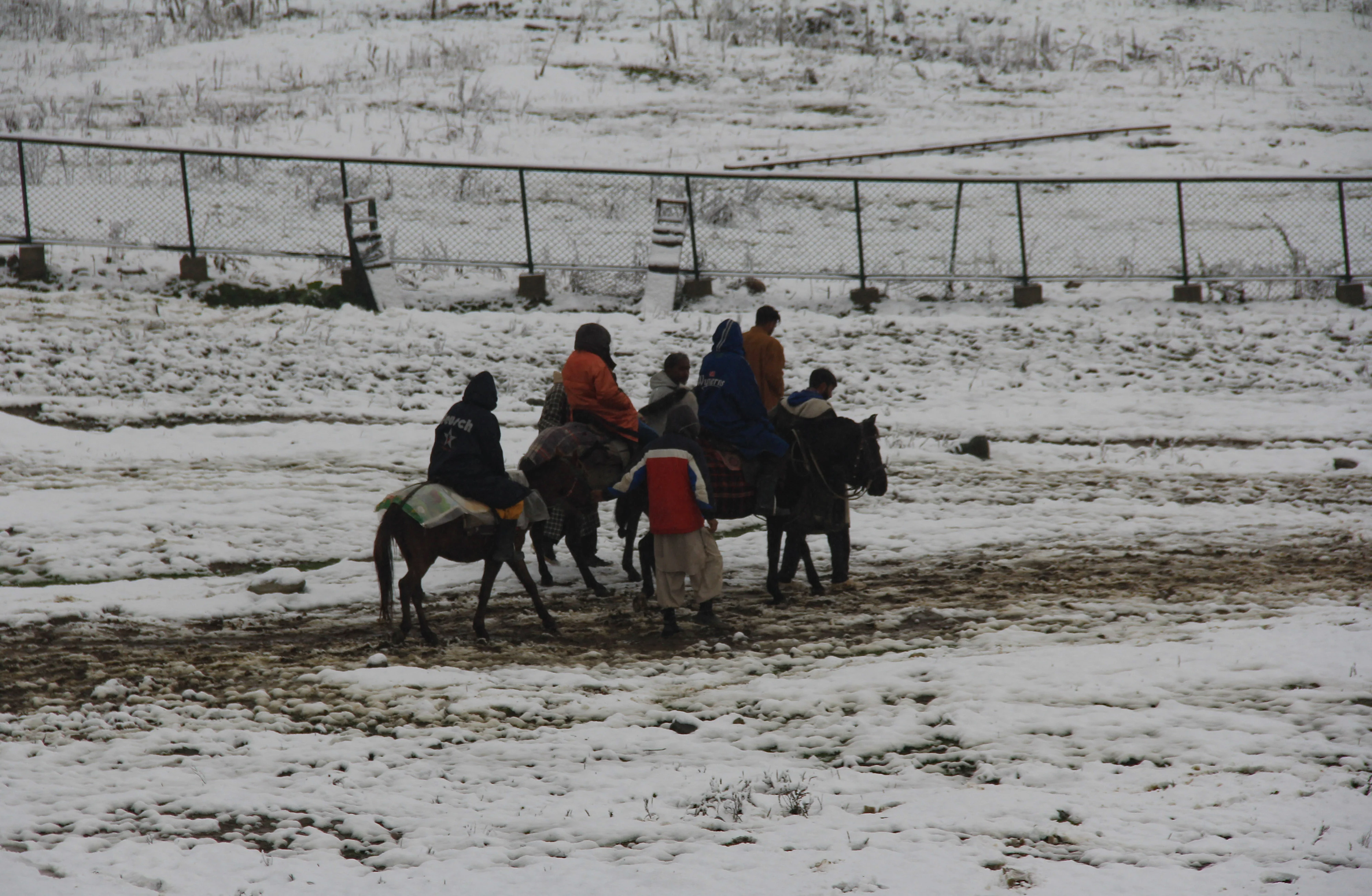 Tourists rides on horses during the season's first snowfall, in World famous Ski resort Gulmarg, Kashmir, On October 23, 2021