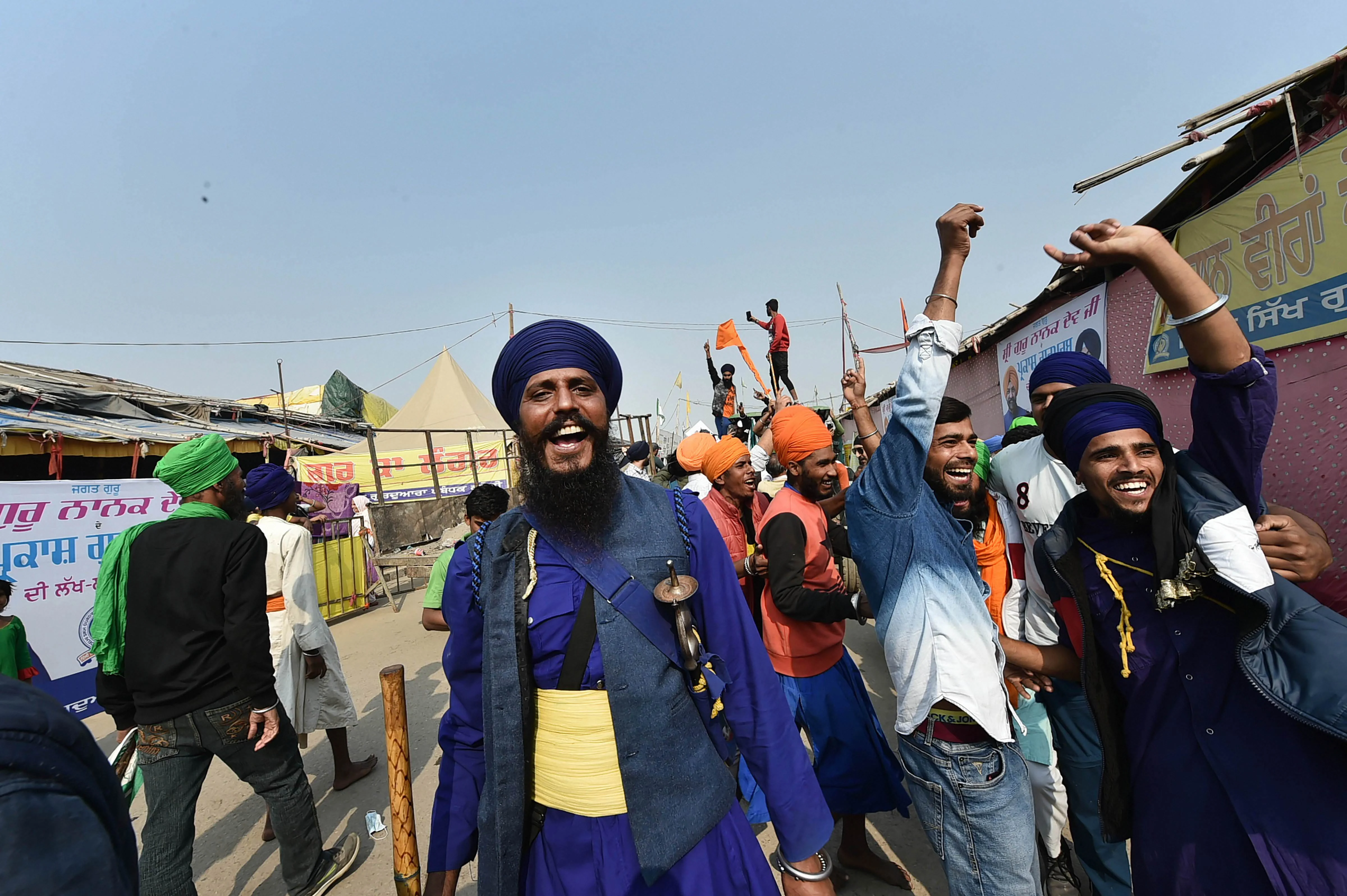 New Delhi: Farmers celebrate after Prime Minister Narendra Modi announced the repealing of the three Central farm laws, at Singhu Border in New Delhi, Friday, Nov. 19, 2021.