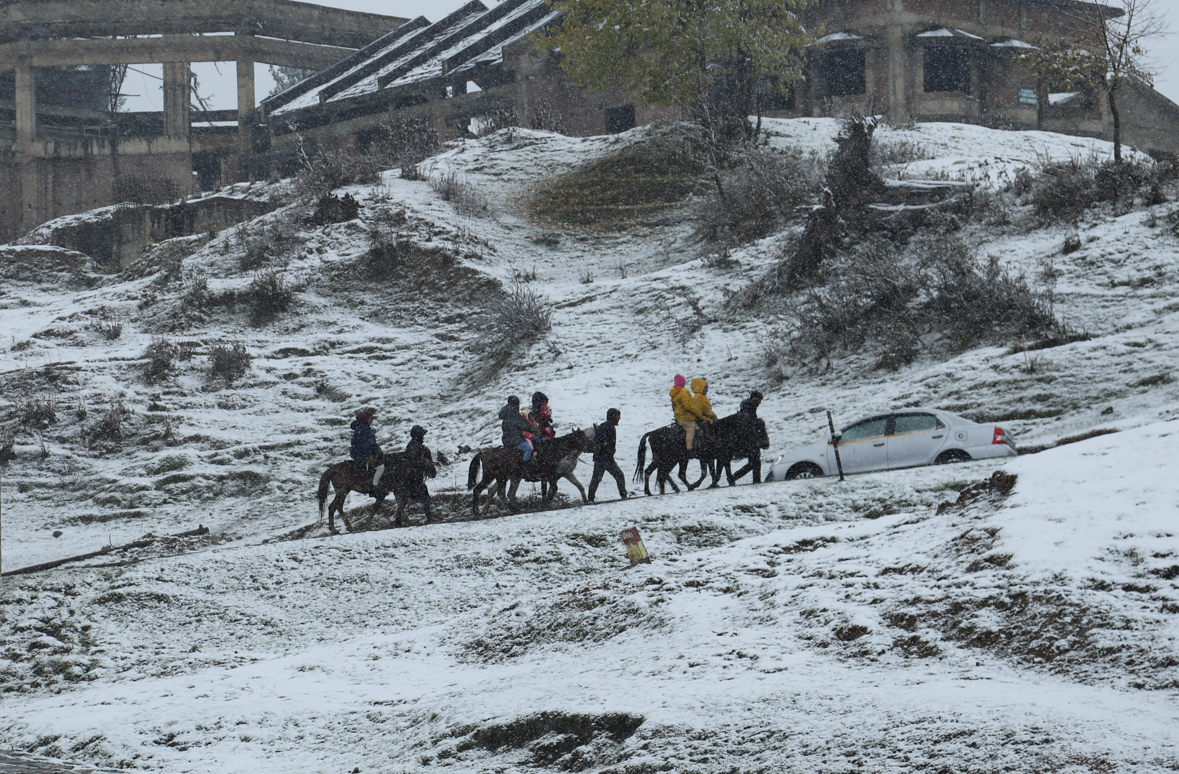 Tourists travel on snow-covered roads during the fresh snowfall at Ski resort in Gulmarg, Jammu and Kashmir on November 05, 2021.