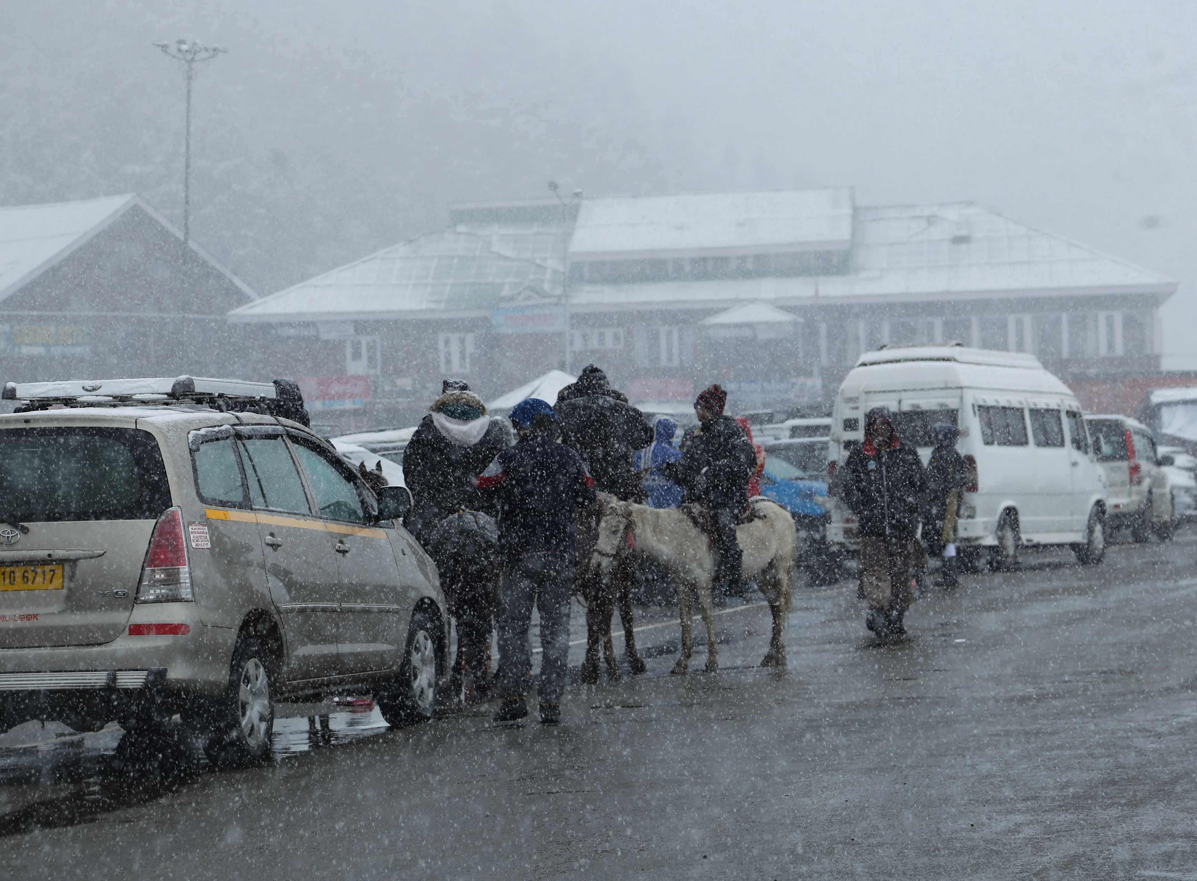 Tourists travel on snow-covered roads during the fresh snowfall at Ski resort in Gulmarg, Jammu and Kashmir on November 05, 2021.