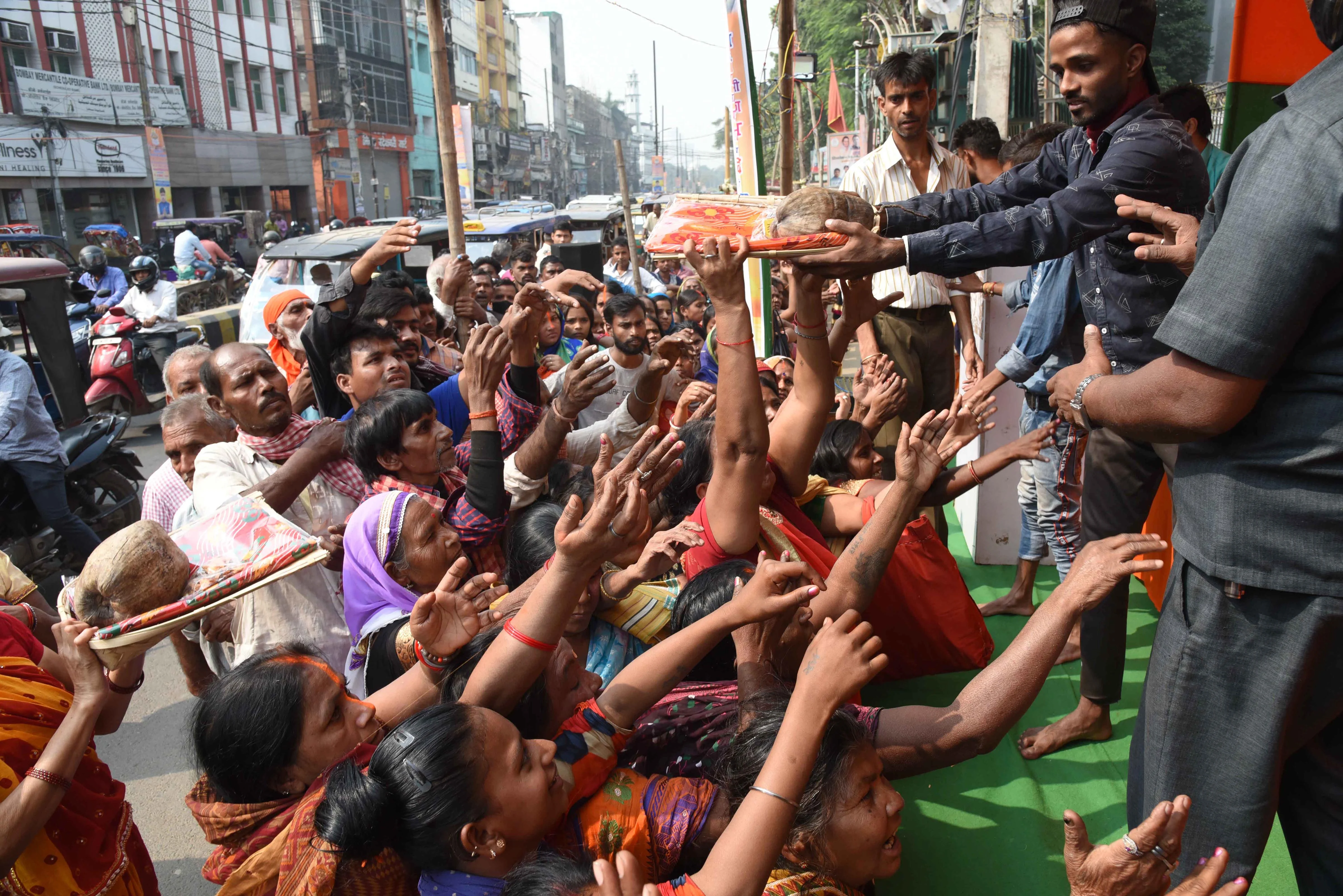 Voulenteers distribute coconuts, saree and other worship items during ongoing four days long Chhath Puja festival in Patna, Monday Nov. 8, 2021.