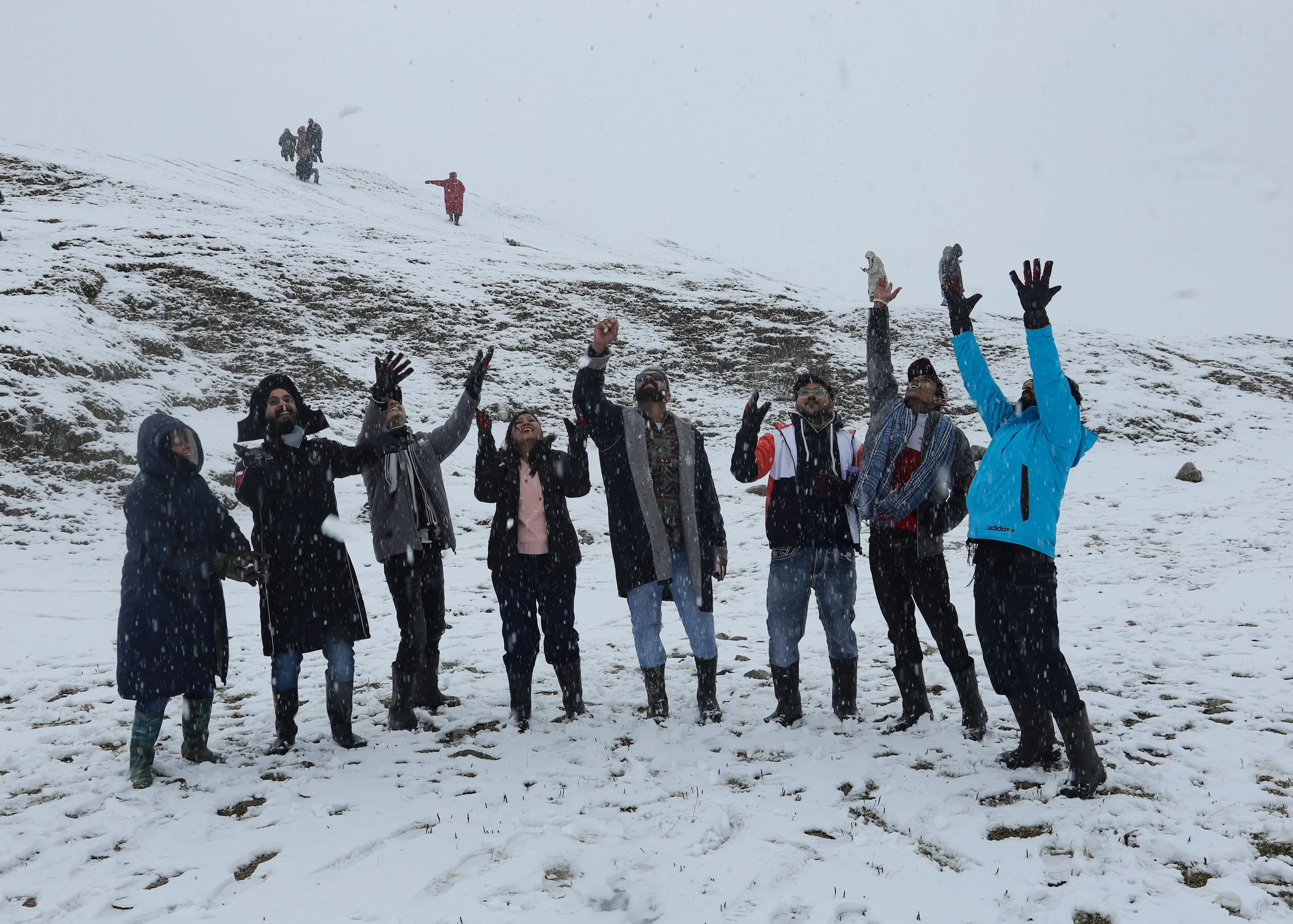 Group of tourists play with snow during the season's first snowfall, at Ski resort in Gulmarg, Jammu and Kashmir on November 05, 2021.
