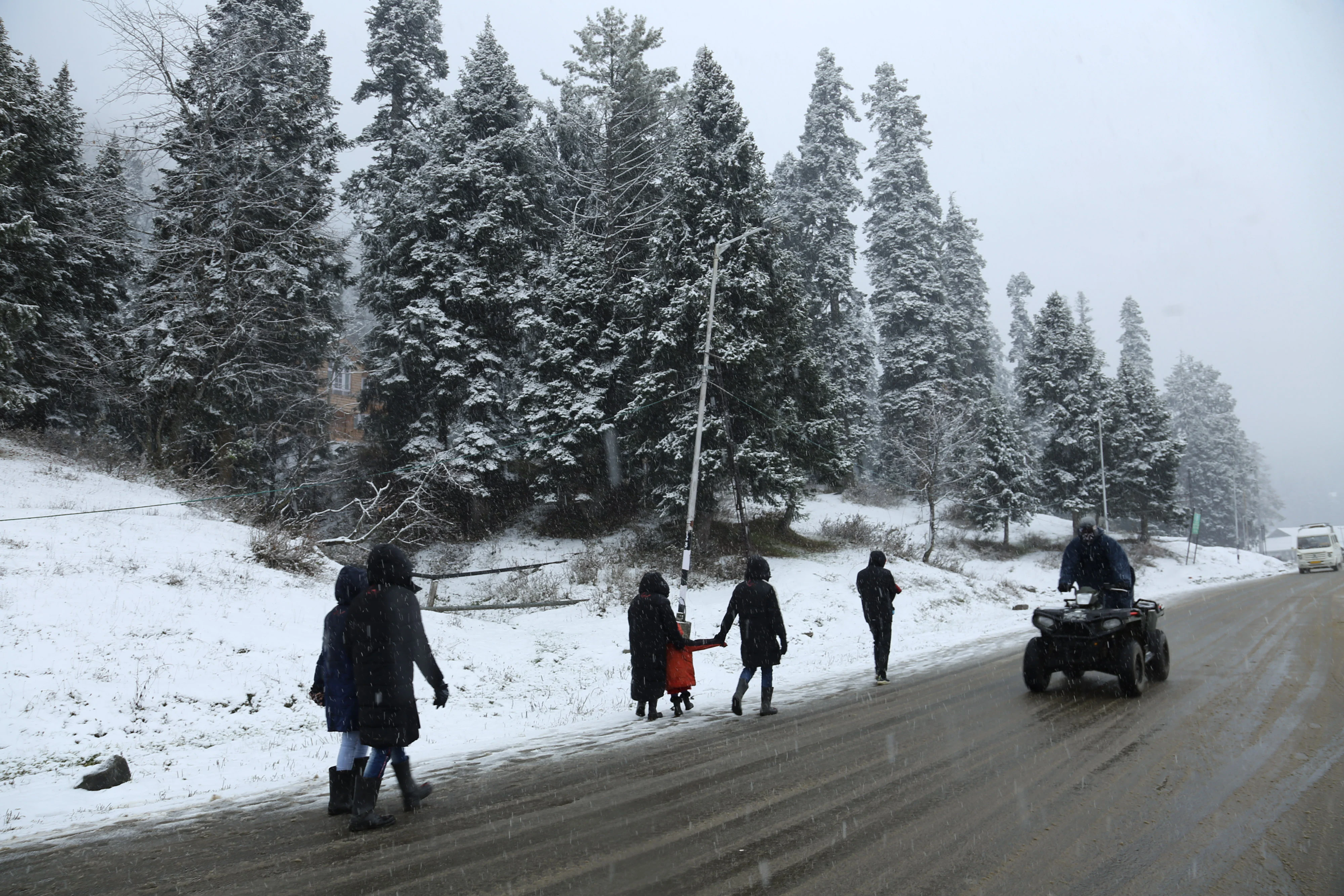 Tourists walk on snow covered gulmarg during the fresh snowfall at Ski resort in Gulmarg, Jammu and Kashmir on November 05, 2021.