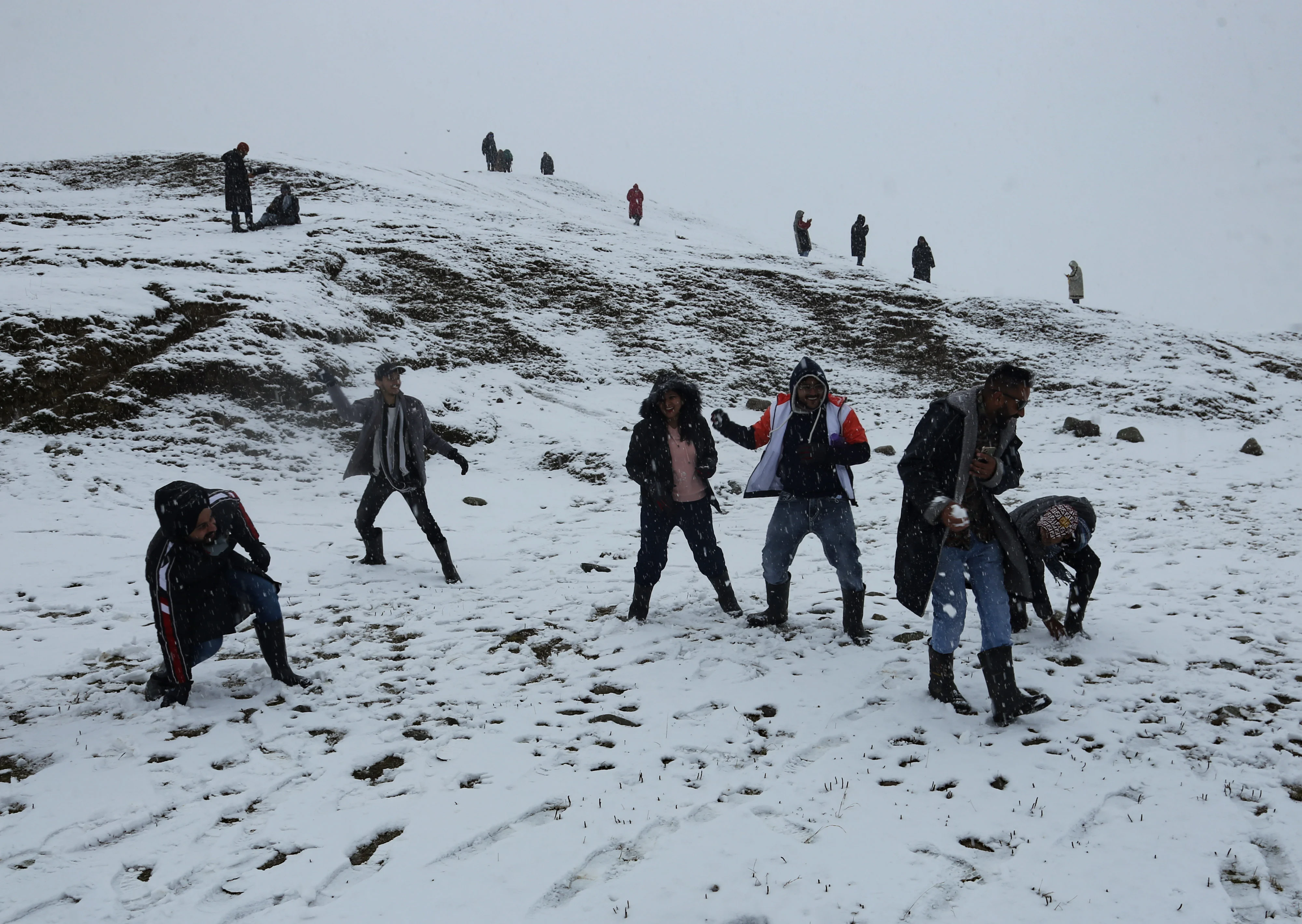 Group of tourists play with snow during the season's first snowfall at Ski resort in Gulmarg, Jammu and Kashmir on November 05, 2021.