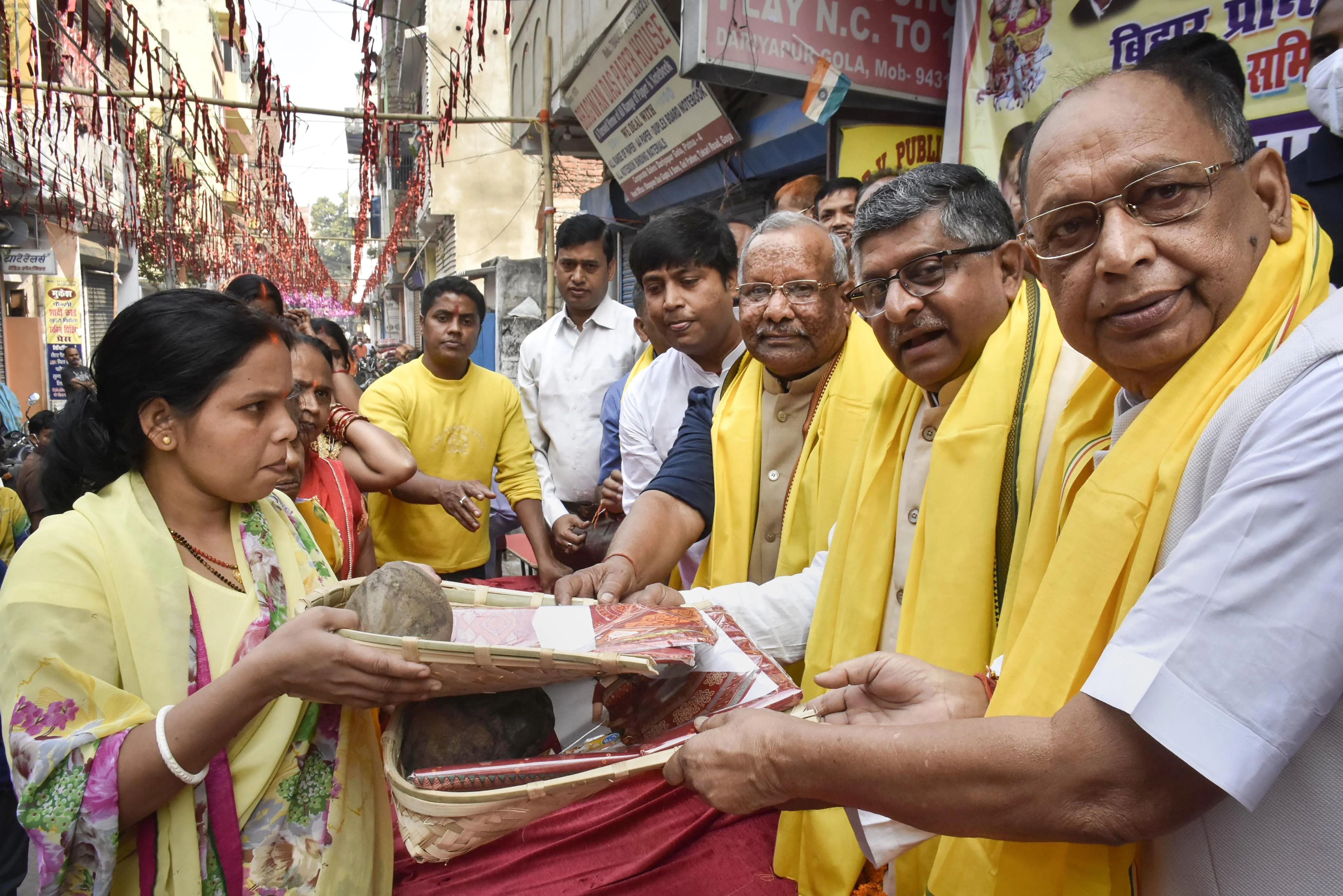 Bihar Deputy CM Tarkishor Prasad along with BJP MP Ravishankar Prasad distribute puja material to women during Chhath Puja festival in Patna, Monday, Nov. 8, 2021.