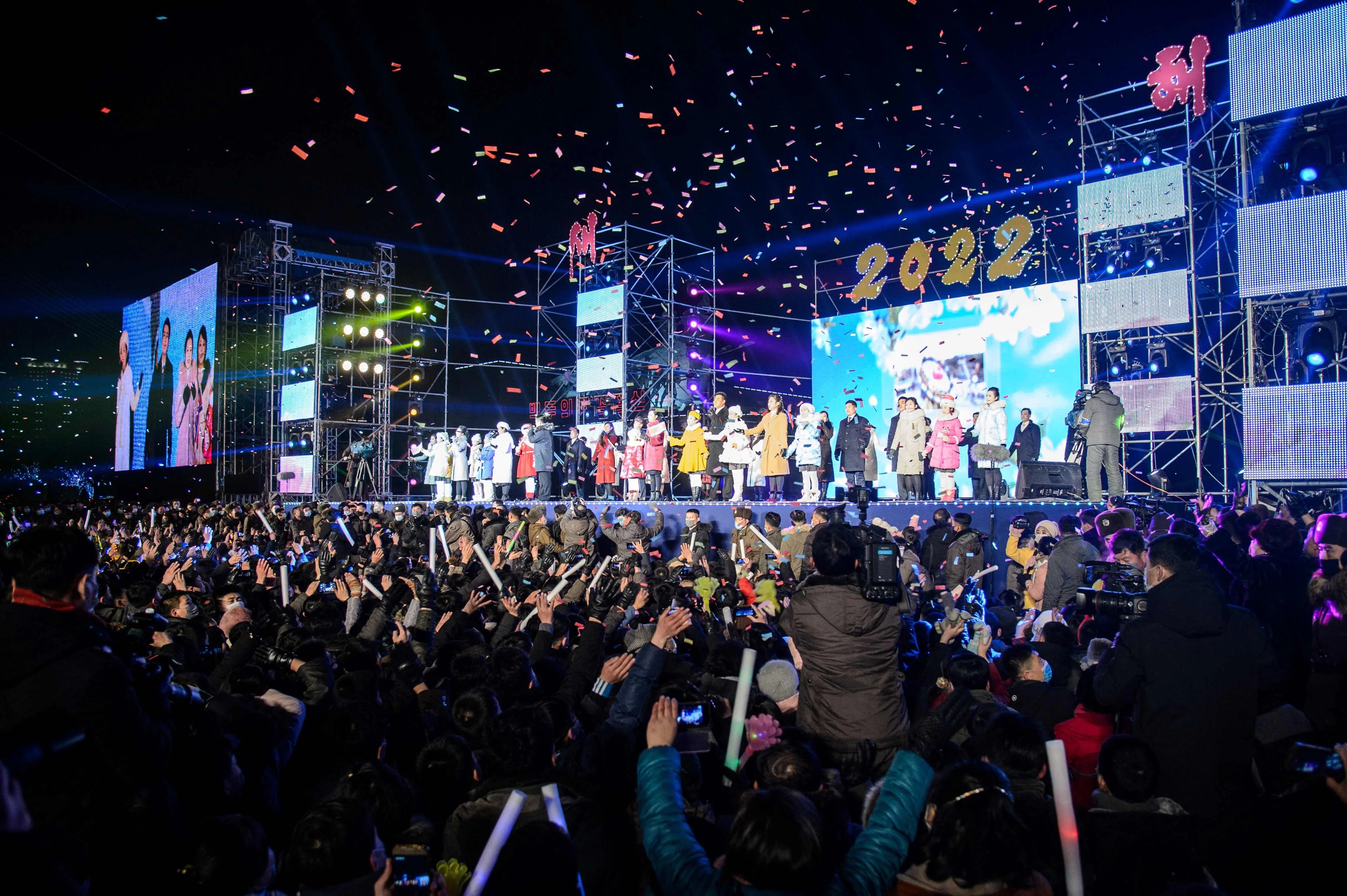 People watch as performers take part in a new year performance on Kim Il Sung Square in Pyongyang late on December 31, 2021.