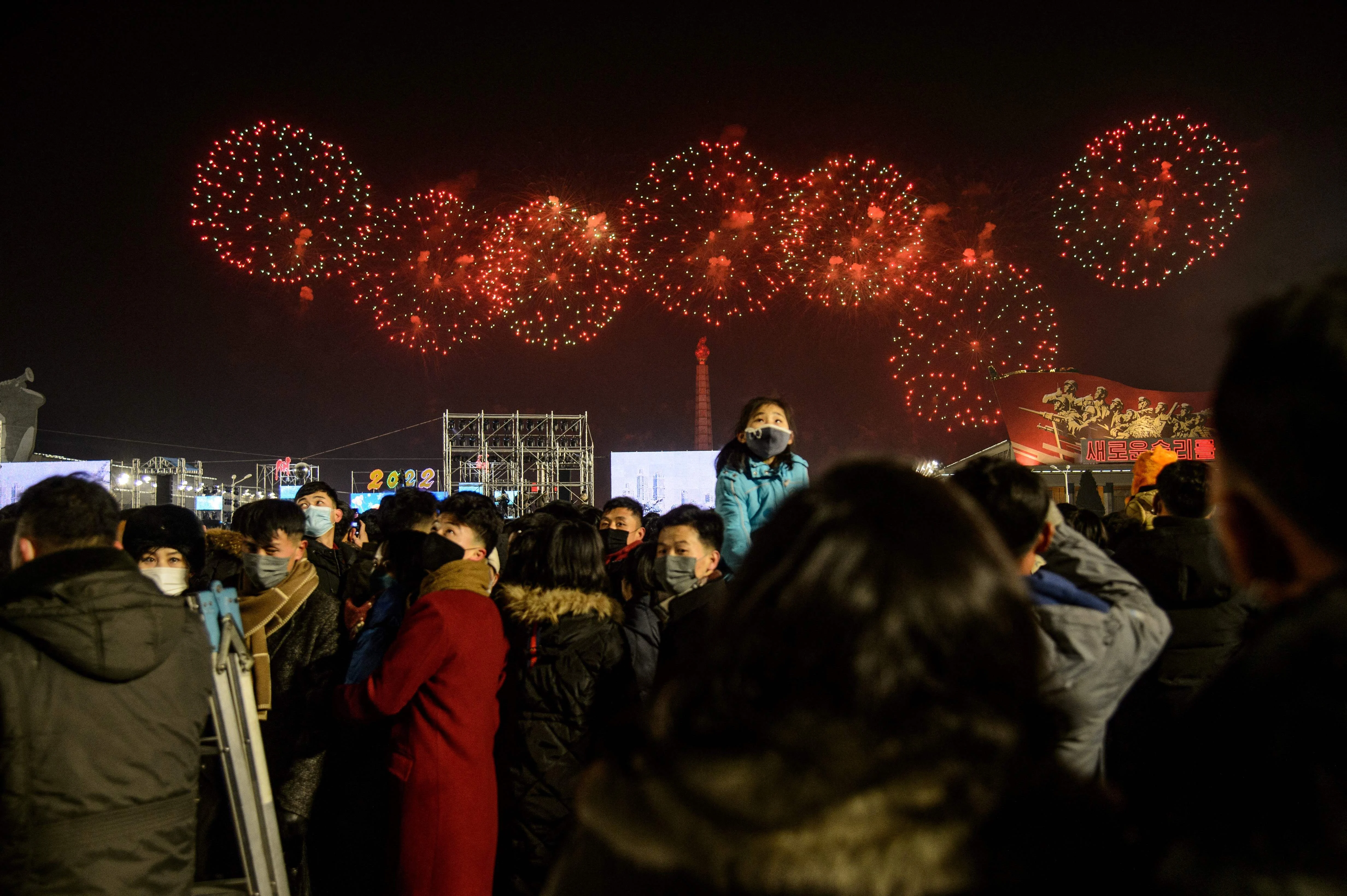People gather to watch a firework display to celebrate the new year on Kim Il Sung Square in Pyongyang on January 1, 2022.