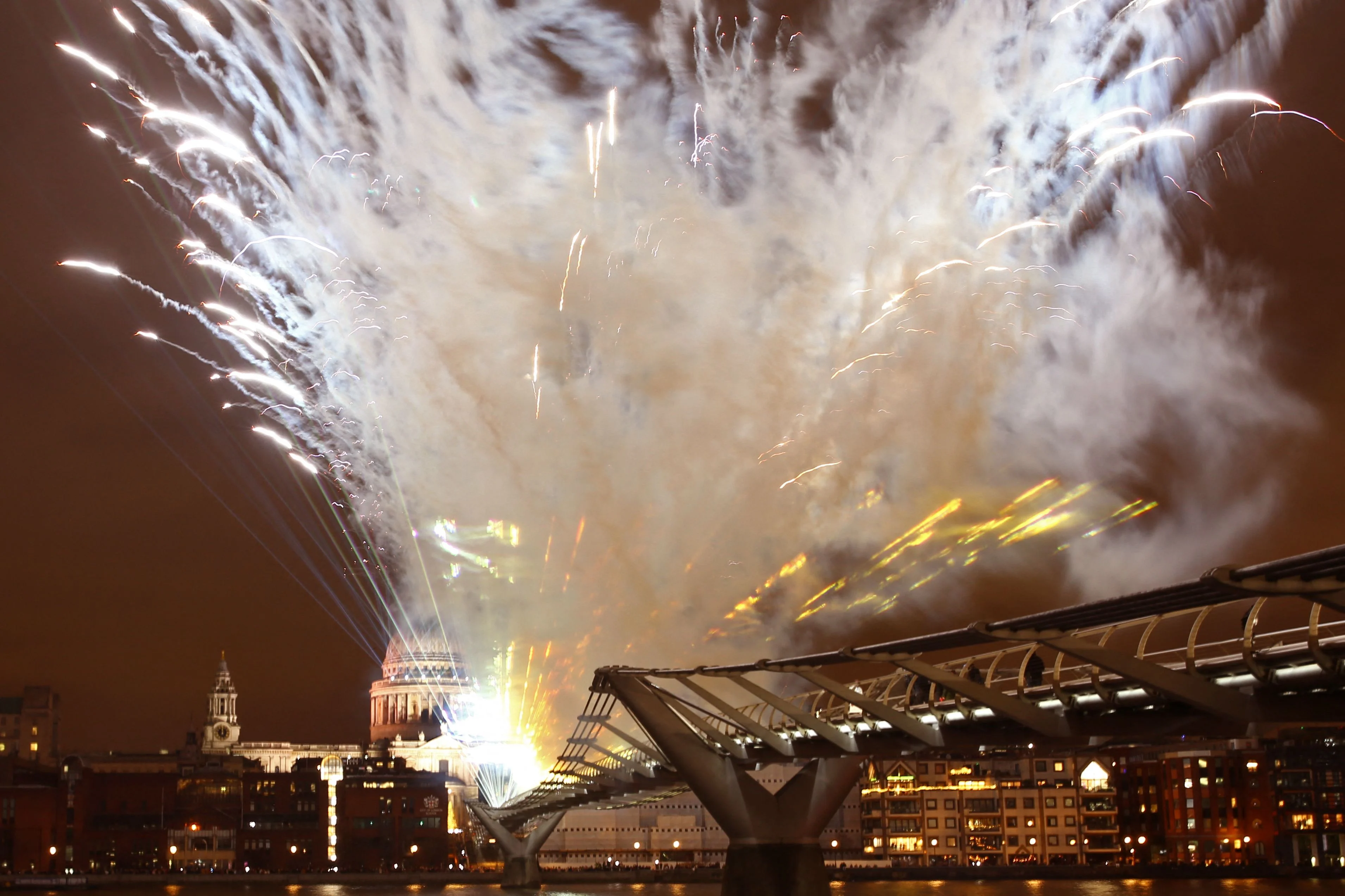A laser display is seen above the Millennium Bridge with St Pauls Cathedral behind, an alternative to the usual New Years fireworks display, in central London just after midnight on January 1, 2022