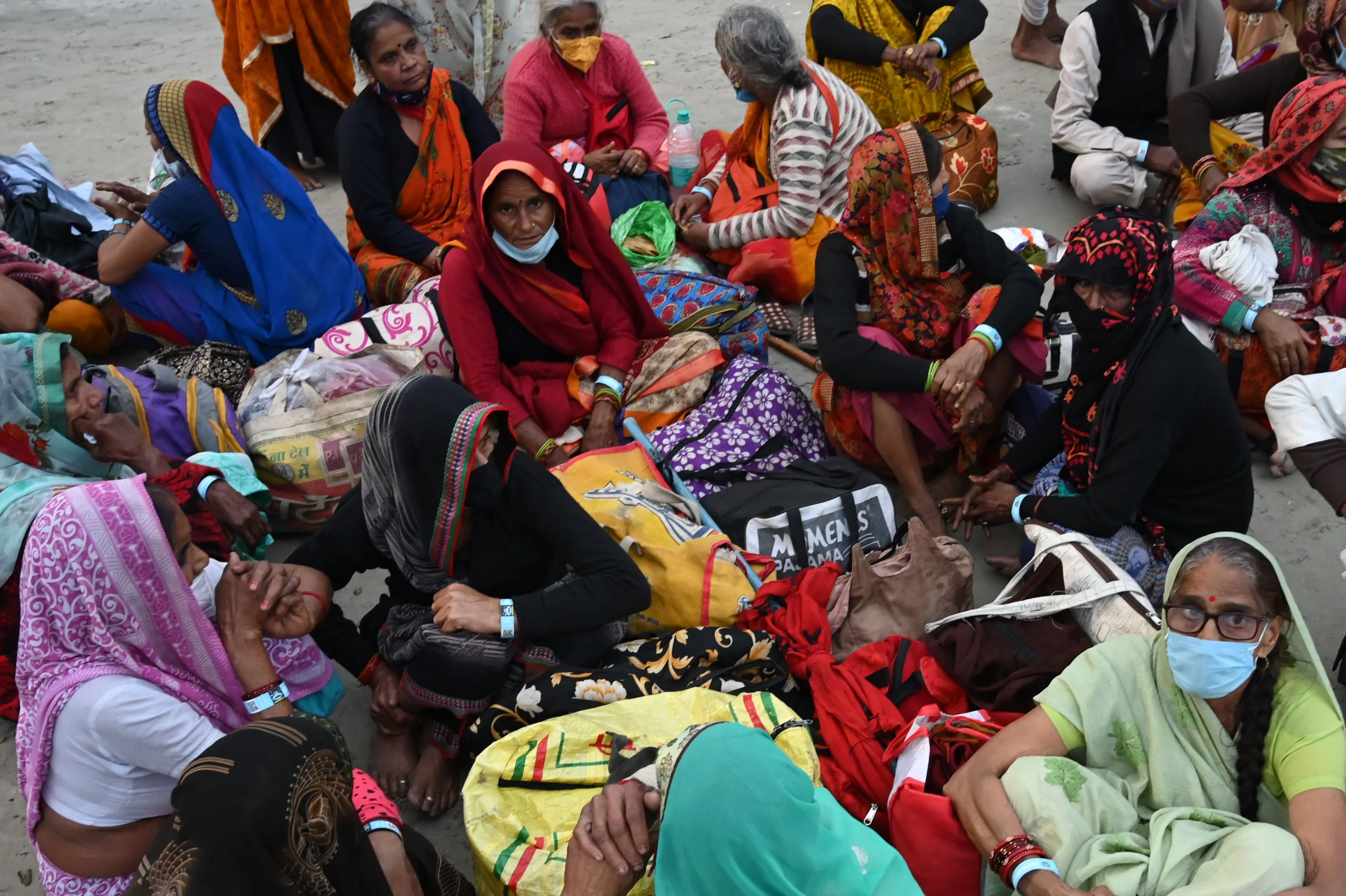 Pilgrims rest as they wait to perform rituals on a beach during the Hindu religious festival of Gangasagar Mela on Sagar Island, some 150 km south of Kolkata, West Bengal, on January 13, 2022.