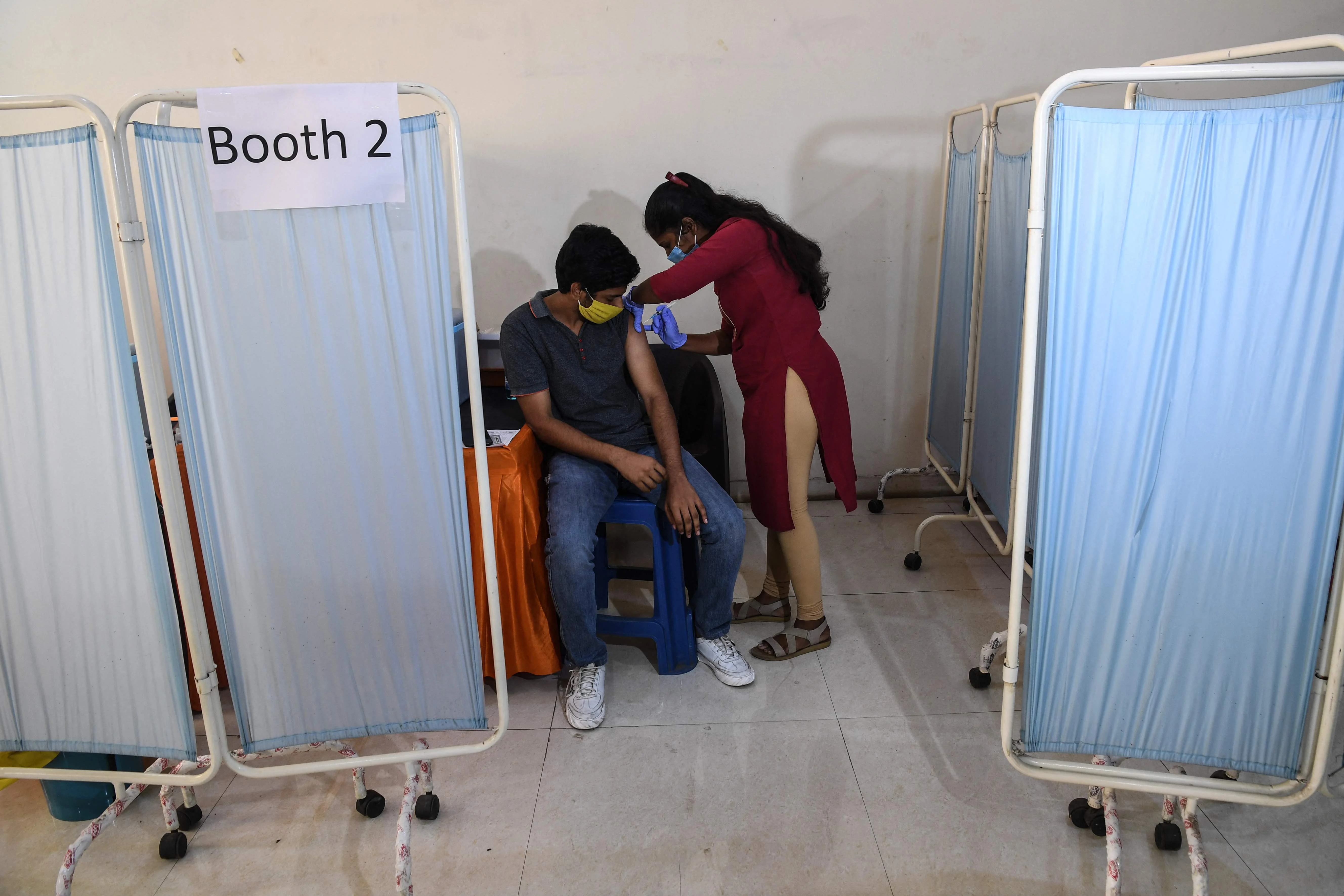 A health worker inoculates a youth with a Covid-19 coronavirus vaccine during a vaccination drive for people in the 15-18 age group, in Mumbai on January 3, 2022