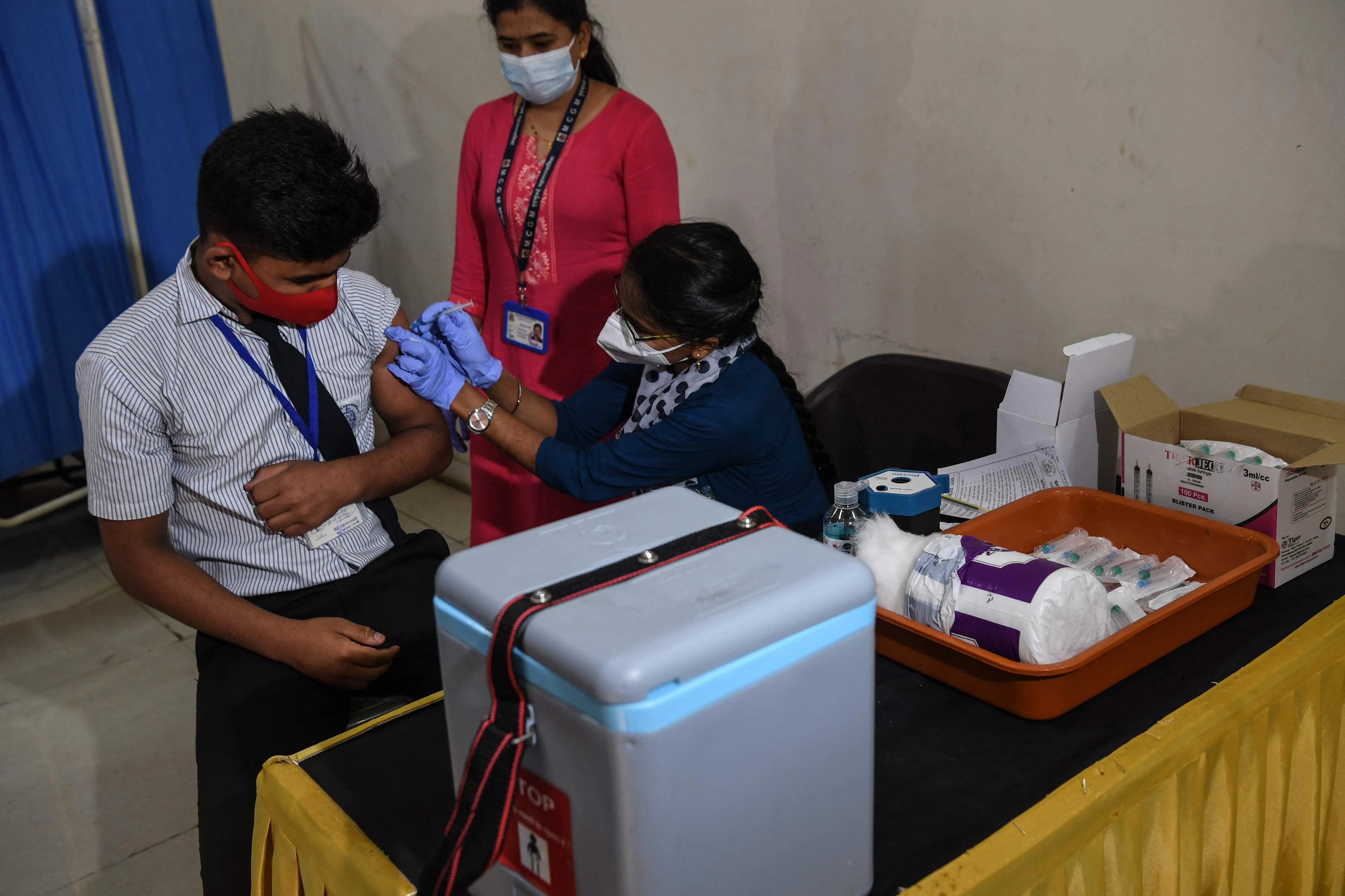 A health worker inoculates a youth with a Covid-19 coronavirus vaccine during a vaccination drive for people in the 15-18 age group, in Mumbai on January 3, 2022.