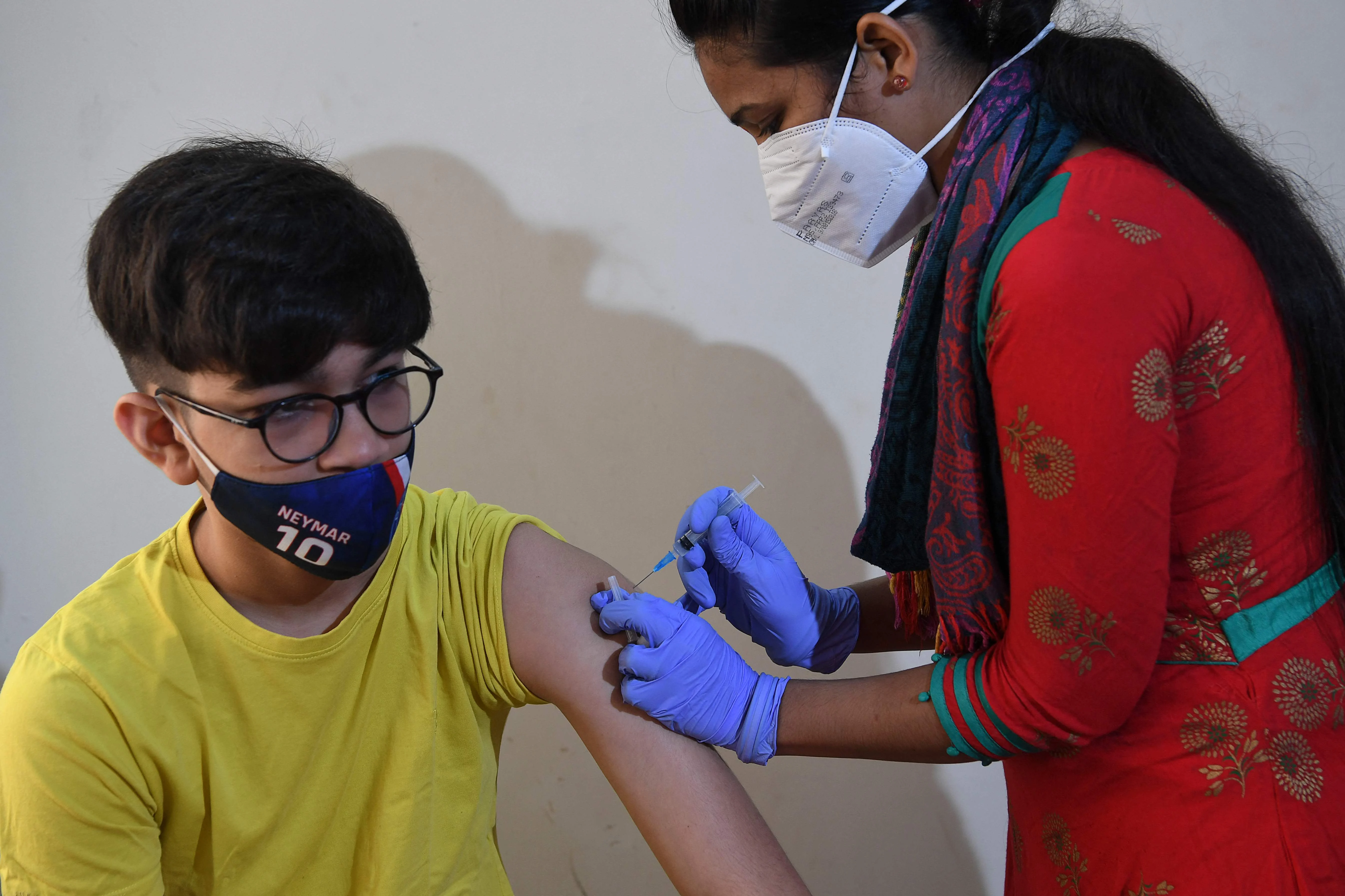A health worker inoculates a youth with a Covid-19 coronavirus vaccine during a vaccination drive for people in the 15-18 age group, in Mumbai on January 3, 2022
