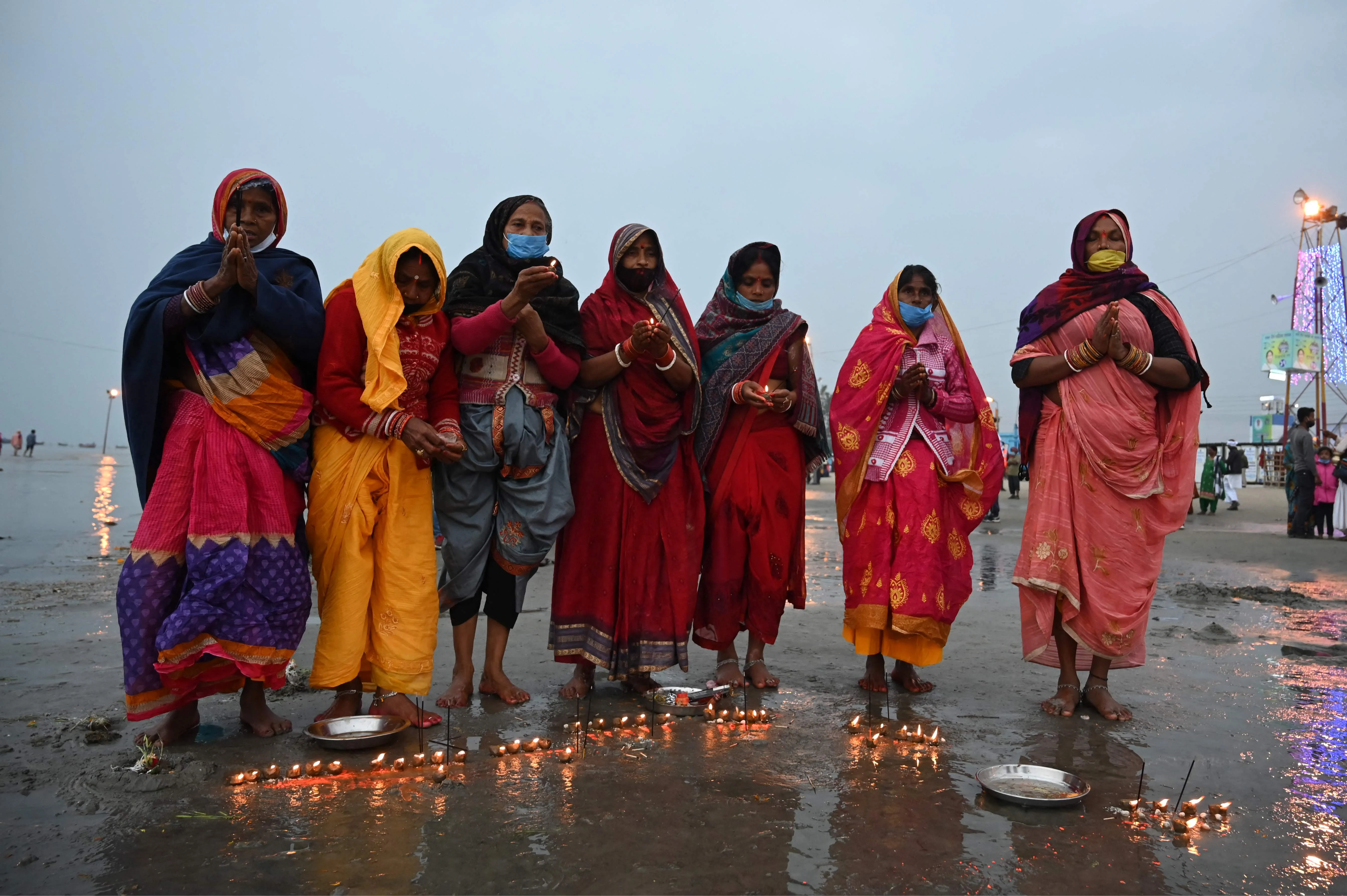 Pilgrims perform rituals on a beach during the Hindu religious festival of Gangasagar Mela on Sagar Island, some 150 km south of Kolkata, West Bengal, on January 13, 2022.