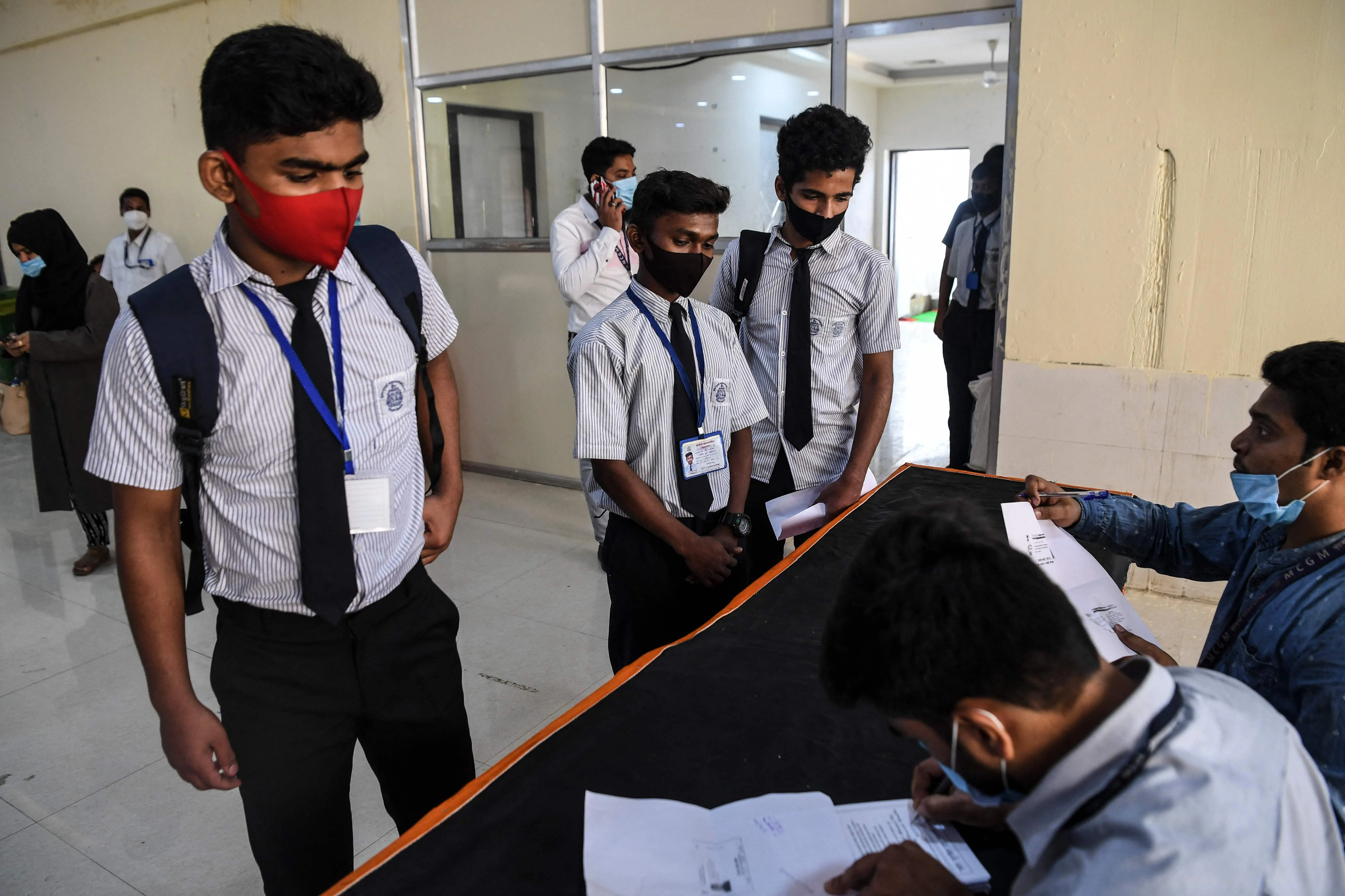 Youths register to receive a dose of a Covid-19 coronavirus vaccine during a vaccination drive for people in the 15-18 age group, in Mumbai on January 3, 2022