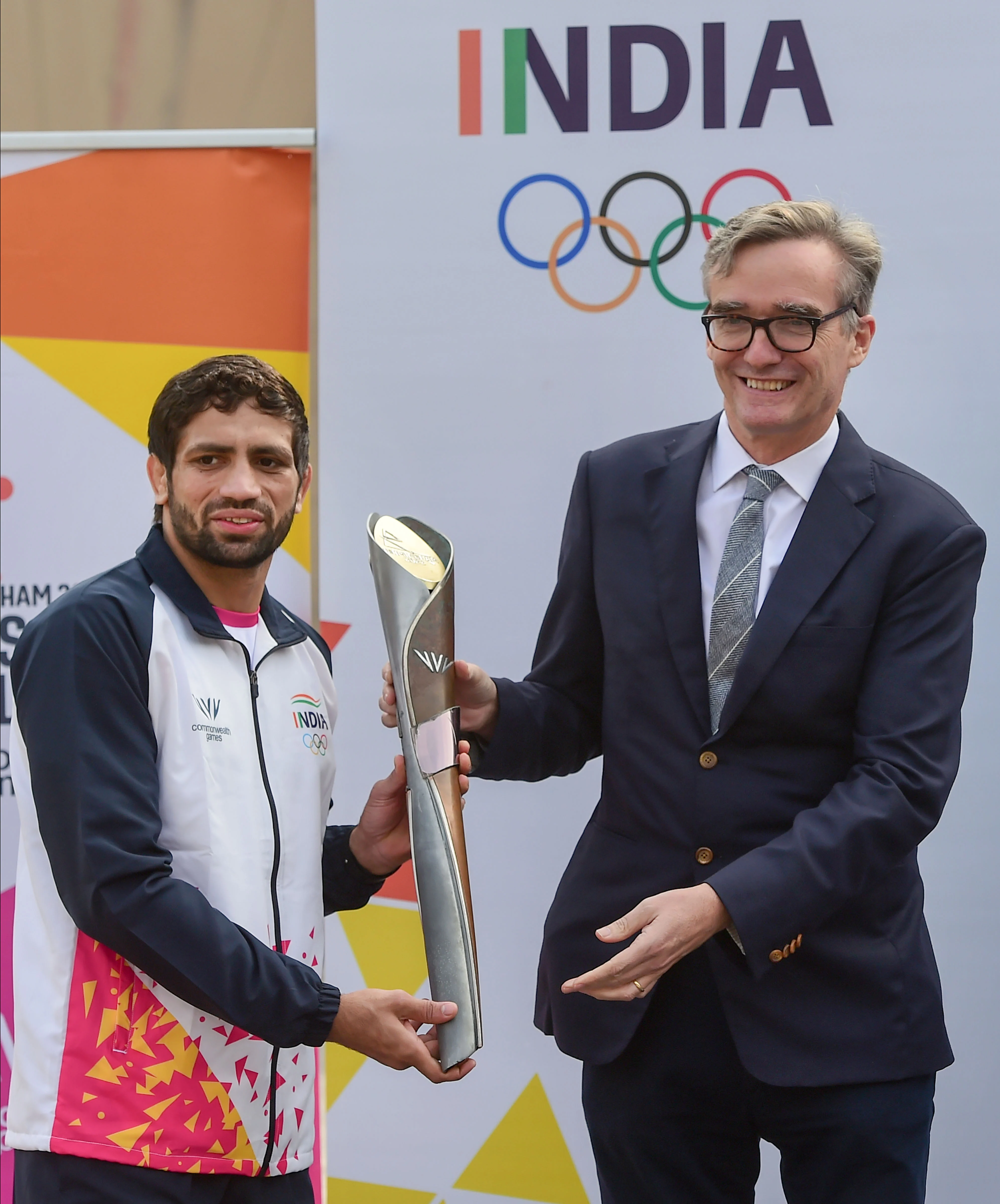 Ravi Dahiya receives the Baton from British High Commissioner to India, Alex Elis