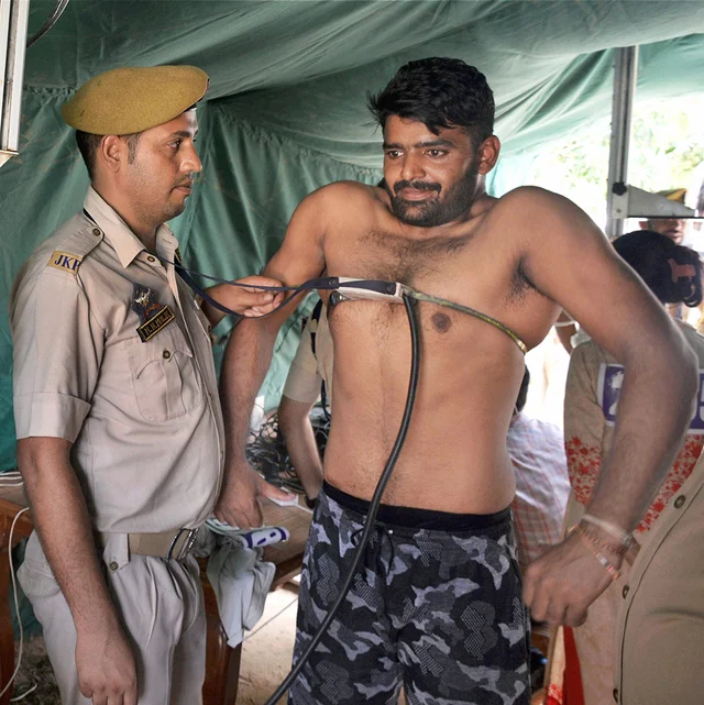 A candidate goes through checks during a Jammu and Kashmir Police recruitment drive for posts of sub-inspectors at Gulshan Ground in Jammu. A candidate goes through checks during a Jammu and Kashmir Police recruitment drive for posts of sub-inspectors at Gulshan Ground in Jammu.