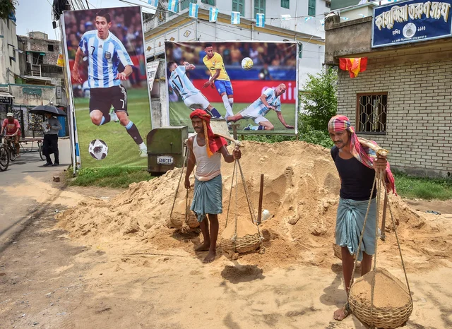 Labourers busy in work in front of posters of Soccer stars as the FIFA World Cup 2018 fever has gripped the locality, in Howrah district of West Bengal. Labourers busy in work in front of posters of Soccer stars as the FIFA World Cup 2018 fever has gripped the locality, in Howrah district of West Bengal.