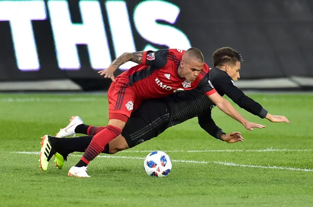 Toronto FC defender Auro, left, takes down D.C. United midfielder Yamil Asad and picks up a yellow card on the play during the first half of an MLS soccer match, in Toronto. Toronto FC defender Auro, left, takes down D.C. United midfielder Yamil Asad and picks up a yellow card on the play during the first half of an MLS soccer match, in Toronto. 
