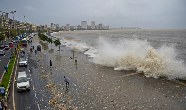 Brihanmumbai Municipal Corporation (BMC) workers clear the garbage washed ashore during high tide on a road along the Marine Drive in Mumbai. Brihanmumbai Municipal Corporation (BMC) workers clear the garbage washed ashore during high tide on a road along the Marine Drive in Mumbai.