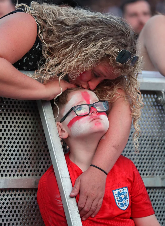 A young fan is consoled as he watches the 2018 World Cup semi final soccer match between Croatia and England in Russia, at the Castlefield Bowl in Manchester, England. A young fan is consoled as he watches the 2018 World Cup semi final soccer match between Croatia and England in Russia, at the Castlefield Bowl in Manchester, England.