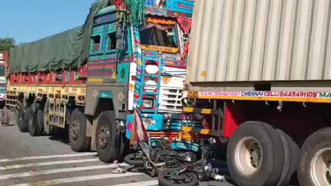 இரண்டு லாரிகளுக்கு இடையே பைக் சிக்கி விபத்து