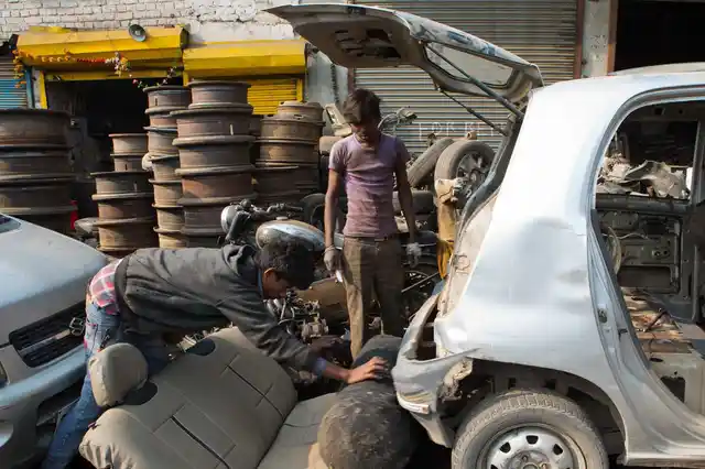 कार से CNG सिलेंडर को निकाला जा रहा है