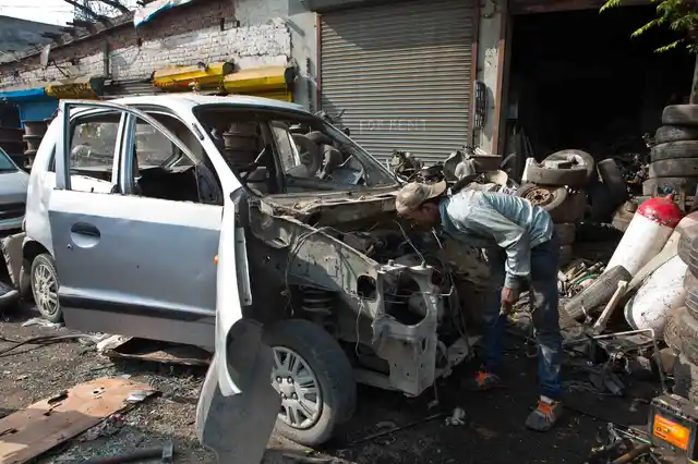 विनोद कुमार मायापुरी के जंकयार्ड में सेंट्रो कार के पुर्जों को अलग करने का काम करते हैं