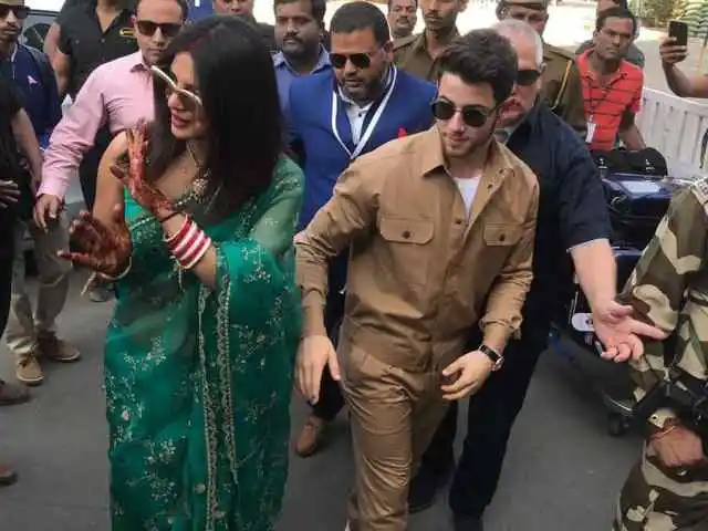 मीडिया का अभिवादन करती हुई प्रियंका, साथ में पति निक जोनास