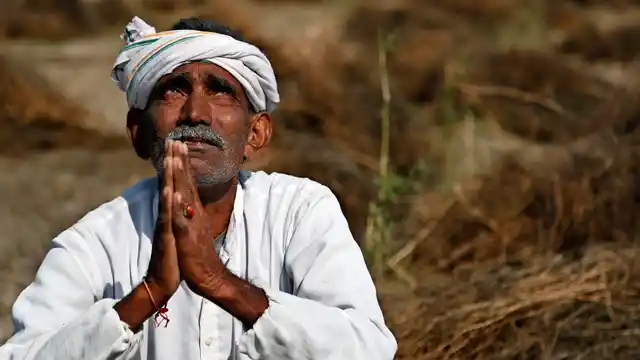 An Indian farmer looks skyward as he sits in his field with wheat crop that was damaged in unseasonal rains and hailstorm at Darbeeji village, in Rajasthan. (Photo: AP)