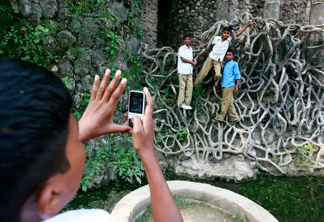 Children pose hanging onto the cement roots at Nek Chand’s Rock Garden (Photo: Reuters)