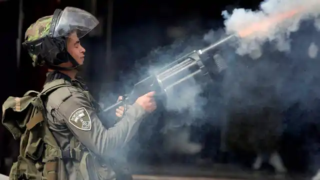 An Israeli policeman fires tear gas during clashes with Palestinian demonstrators, in the West Bank town of al-Ram, north of Jerusalem, October 22, 2015. (Photo: PTI)