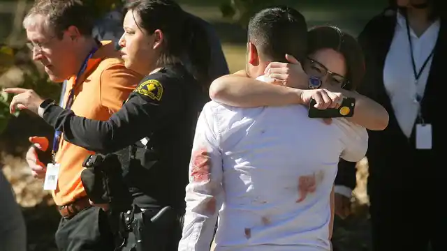 A couple embraces following the California shooting that killed multiple people at a social services facility. (Photo: AP)