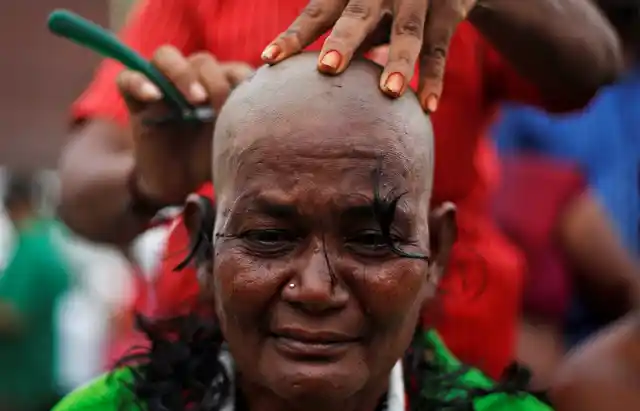 A woman supporter of Jayalalithaa gets her head shaved near the burial site in Chennai. (Photo: Reuters)