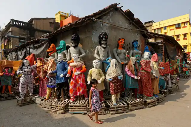A girl walks past clay idols of the Hindu mythological characters ‘Dakinis’ and ‘Yoginis’, who will be worshipped along with the Hindu goddess Kali during the Kali Puja festival, at a roadside workshop in Kolkata, India October 17, 2017.