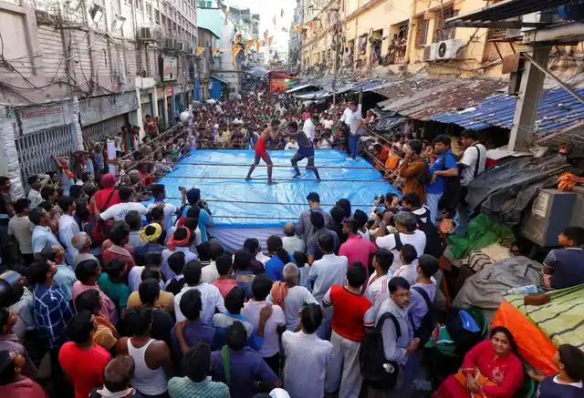 Wrestlers fight during an amateur wrestling match inside a makeshift ring installed on a road organised by local residents as part of Diwali, the festival of lights, celebrations in Kolkata, India, October 18, 2017. 