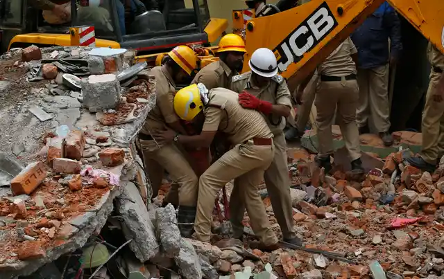 Rescue workers remove the debris to look for survivors at the site of a building that collapsed in Bangalore, India, Monday, Oct. 16, 2017. A two-story building collapsed early Monday when a cooking gas cylinder exploded in a residential building in southern India. 