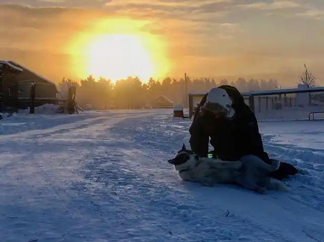 Man and dog play in freezing temperature of -62 degree celsius in Oymyakon.