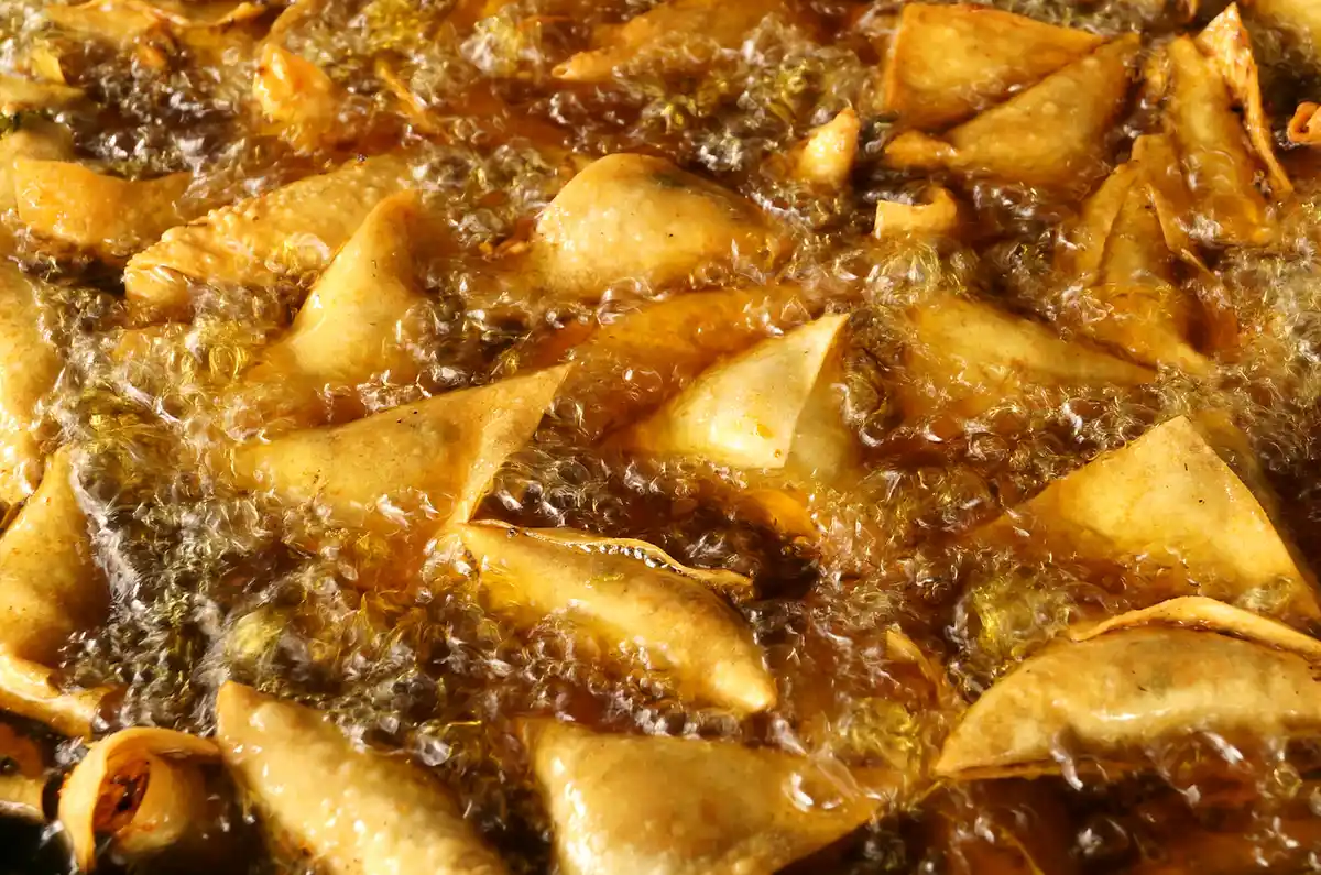 Triangles fried in the hue of the Tuscan sun are scooped up with a large perforated ladle.