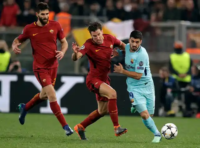 Barcelona’s Luis Suarez, right, is challenged by Roma’s Kevin Strootman during the Champions League.