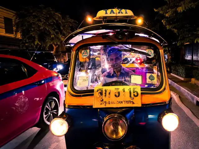 A tuk tuk waits for the traffic signal to turn green.