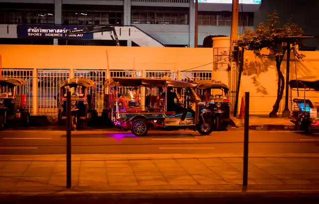 Kho talks to his tuk tuk driver friends while waiting for customers at the stand.