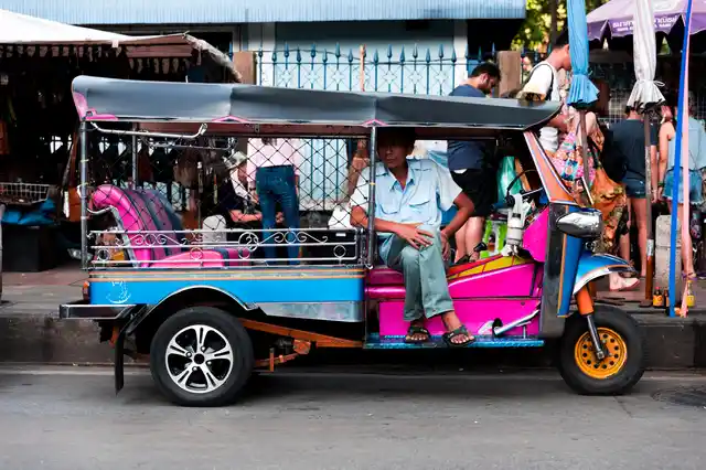 A tuk tuk eagerly waits for customers at the gate of Chatuchak market.