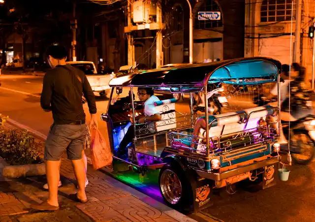 A tuk tuk driver poses for a photo after he dropped off a customer.