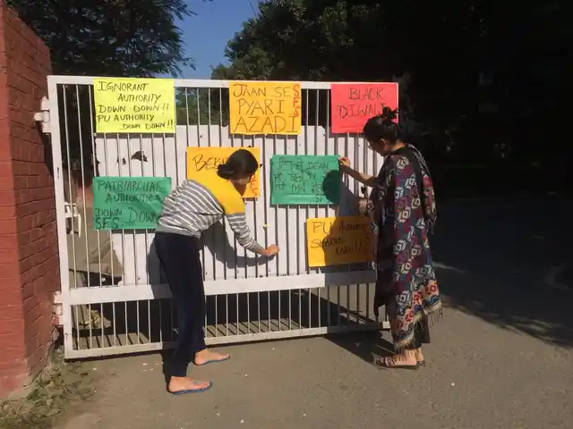 Women put up posters at the Panjab University in Chandigarh.